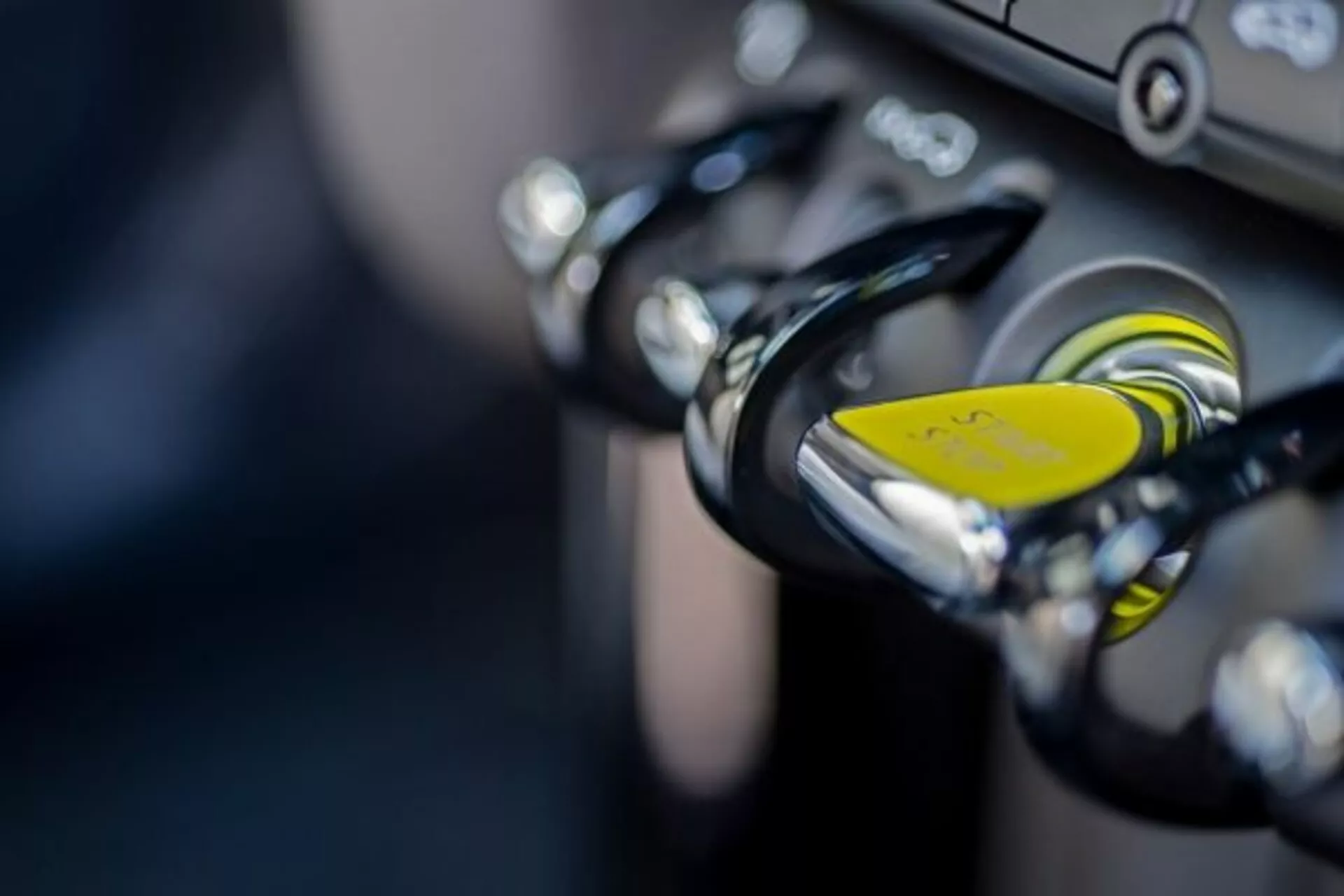 Gros plan sur l'allumage d'une moto avec entrée clé et porte-clés jaune, mettant en avant la technologie antivol et les guidons accentués de chrome, illustrant les fonctionnalités de haute qualité de conception et de sécurité.