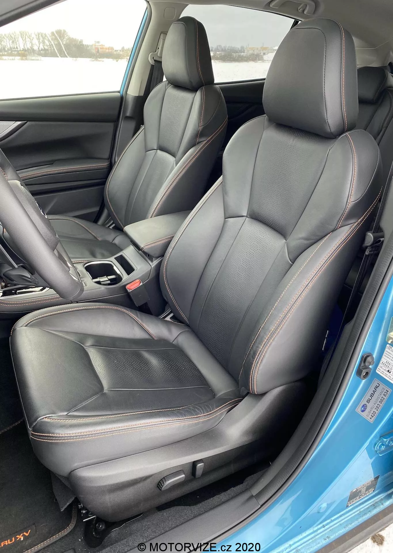 Intérieur de la Subaru XV 2018 1.6i Trend Lineartronic avec sièges avant conducteur et passager en cuir noir avec surpiqûres rouges, vu de l'extérieur du côté conducteur avec la porte ouverte.