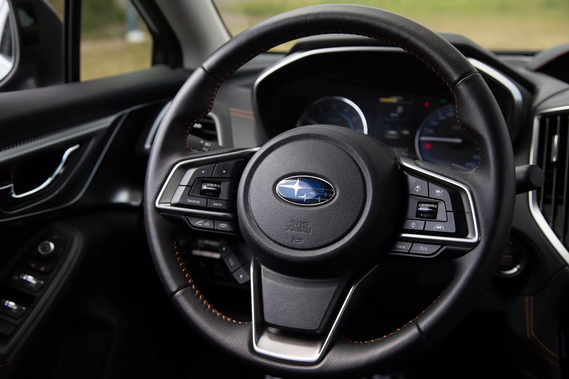 Vue rapprochée du volant du Subaru XV 2021 mettant en évidence ses boutons multifonctions, son revêtement en cuir luxueux et son tableau de bord moderne avec écrans numériques