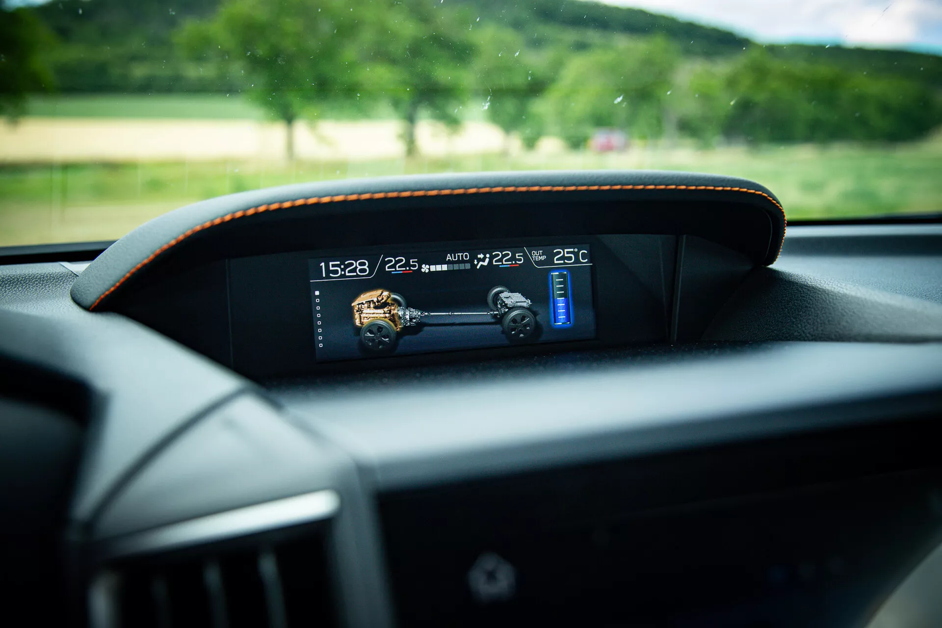 Vue rapprochée du tableau de bord numérique moderne dans une Subaru XV 2021, affichant les indicateurs de temps, température et vitesse avec une couture contrastée subtile autour du cadre, prise du point de vue du siège du conducteur