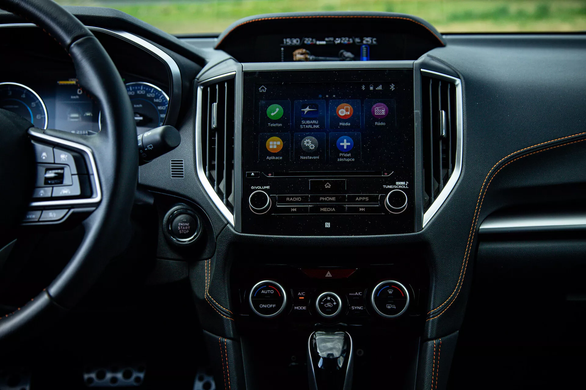 Intérieur du Subaru XV 2021 mettant en lumière la console centrale et le système d'infodivertissement depuis une perspective de siège arrière, affichant l'écran tactile avec des icônes d'applications, des boutons de contrôle audio et climatique, reflétant la technologie avancée et le design de luxe