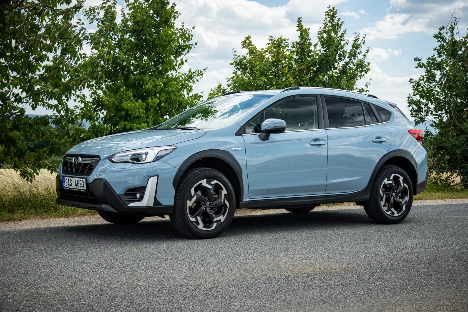 SUV crossover Subaru XV 2021 bleu clair stationné sur l'asphalte présentant profil latéral, jantes en alliage noires distinctives, feux arrière LED, garde au sol élevée pour utilisation urbaine et légère hors route, et caractéristiques de sécurité modernes