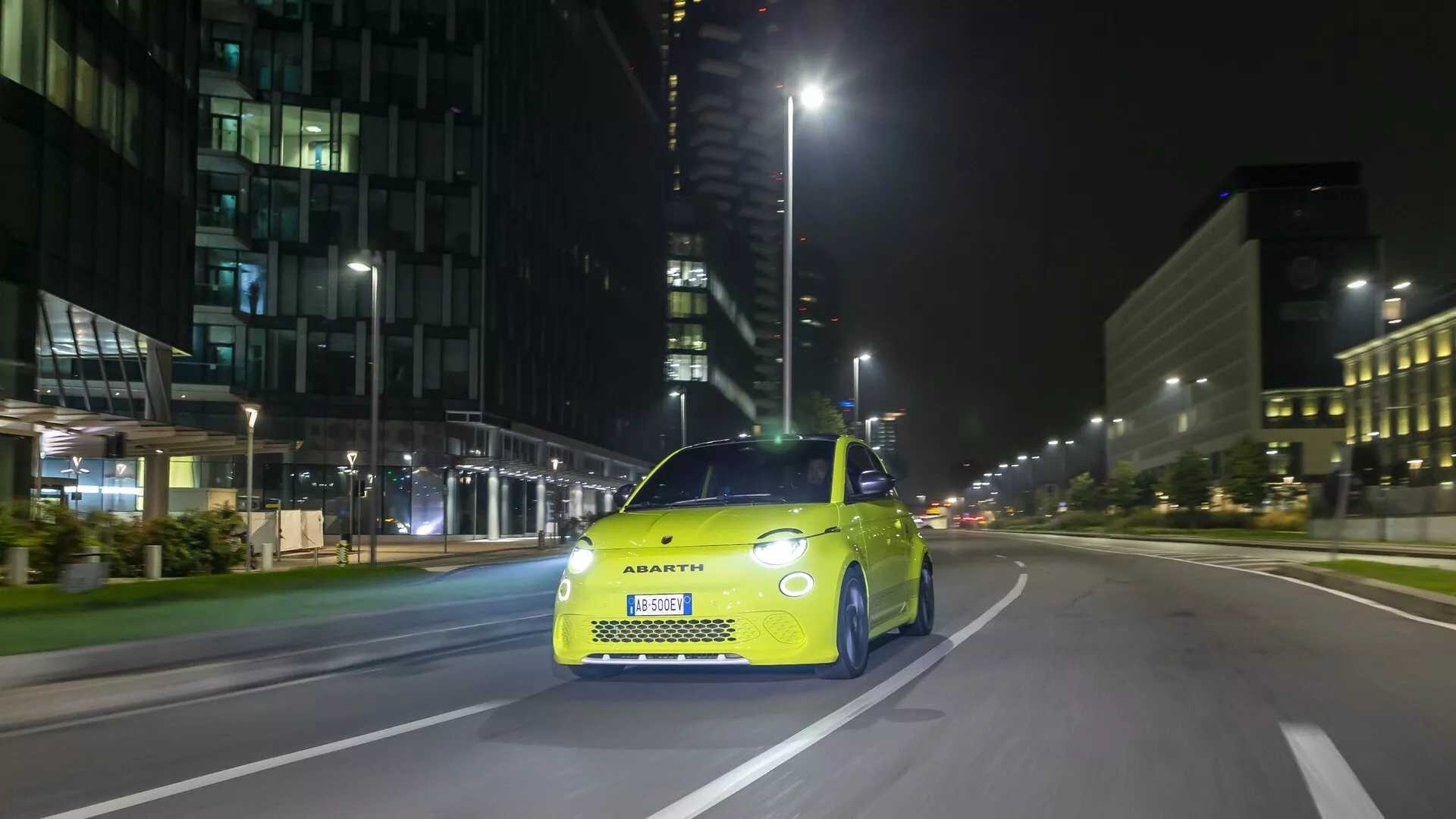 Photographie de l'Abarth 500, 595 et 695 (2e génération) de 2023 prise sous un angle avant-droit, mettant en évidence sa calandre distinctive, ses phares à LED et ses éléments de design sportif. La voiture est stationnaire dans une rue urbaine, capturant à la fois les caractéristiques technologiques et la silhouette compacte et élégante qui incarnent la marque Abarth.