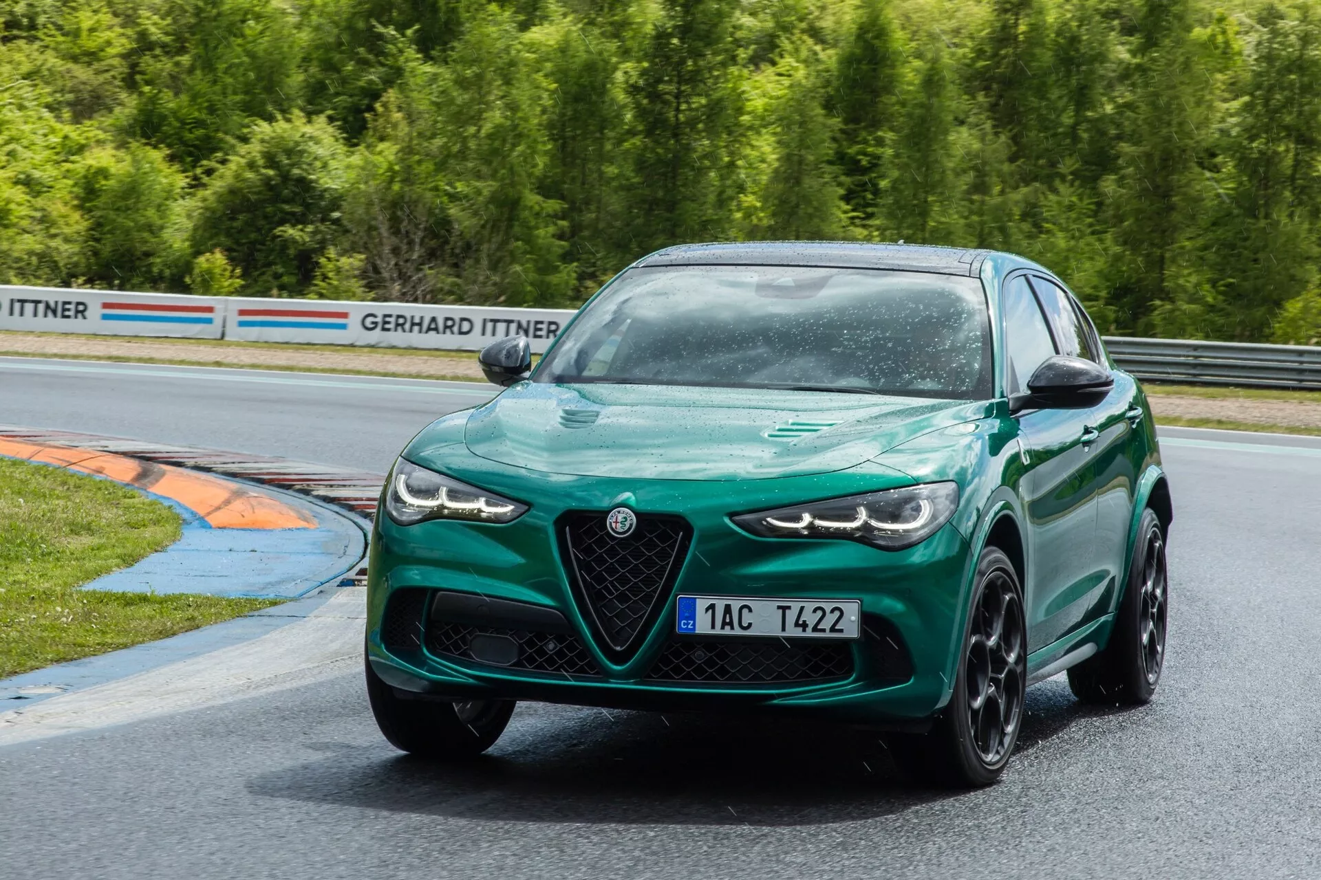 Alfa Romeo Giulia Quadrifoglio 2023 en vert foncé vibrant, démontrant son élégance sportive avec des phares LED de pointe et un design axé sur la performance sur un circuit de course, incarnant la dynamique de la berline sportive moderne.