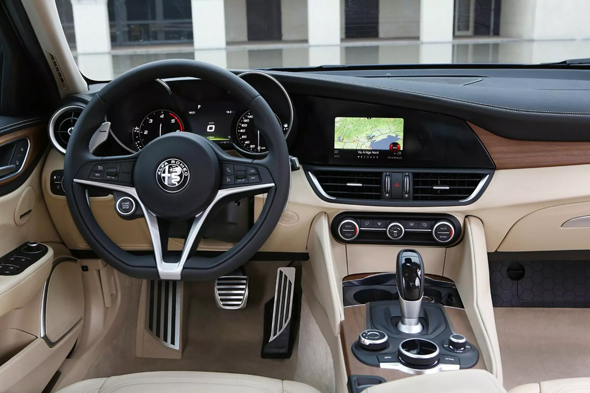 Vue intérieure de l'Alfa Romeo Giulia 2016 montrant le côté conducteur avec volant en cuir, tableau de bord et console centrale