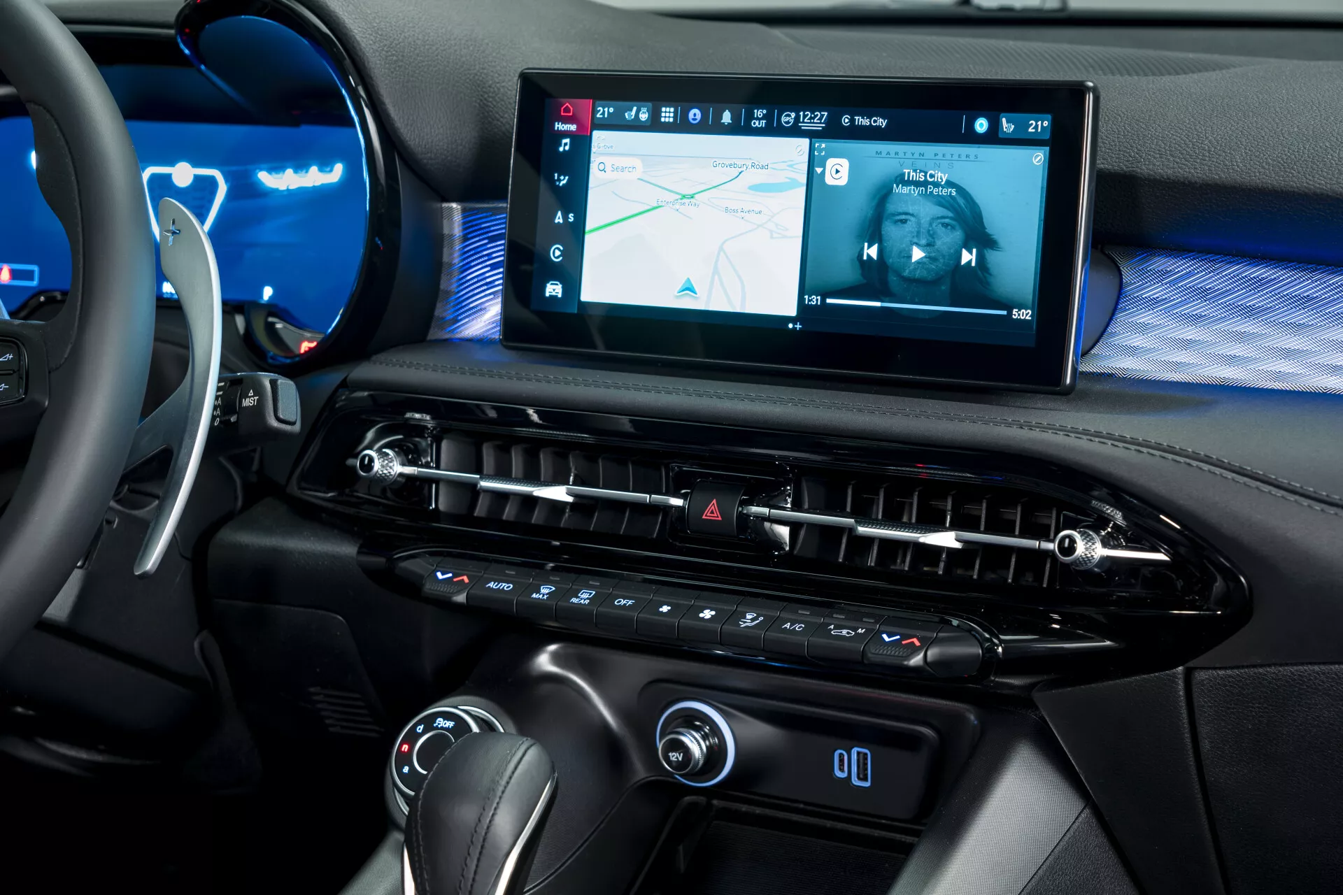Vue rapprochée de l'intérieur de l'Alfa Romeo Tonale 2022 (965), montrant le tableau de bord du point de vue du siège passager avant avec un grand système d'infodivertissement tactile, une bouche d'air allongée et des commandes de climatisation modernes.