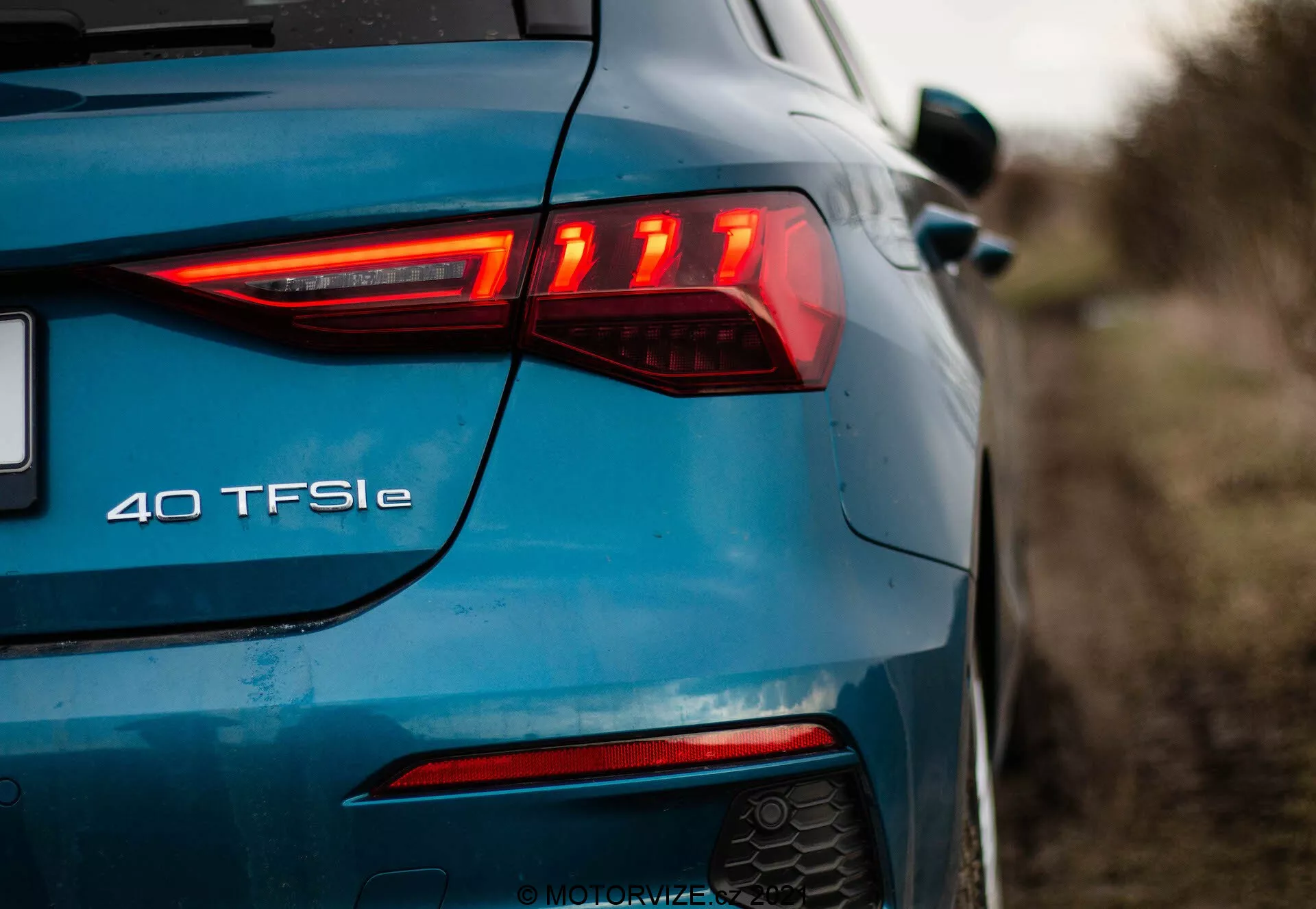 Vue arrière-gauche de l'Audi A3 2020 Sportback bleue, mettant en évidence le design moderne des feux arrière à LED avec des éléments horizontaux, le feu antibrouillard arrière, le système d'échappement double et le badge '40 TFSI e' indiquant une motorisation hybride électrique.