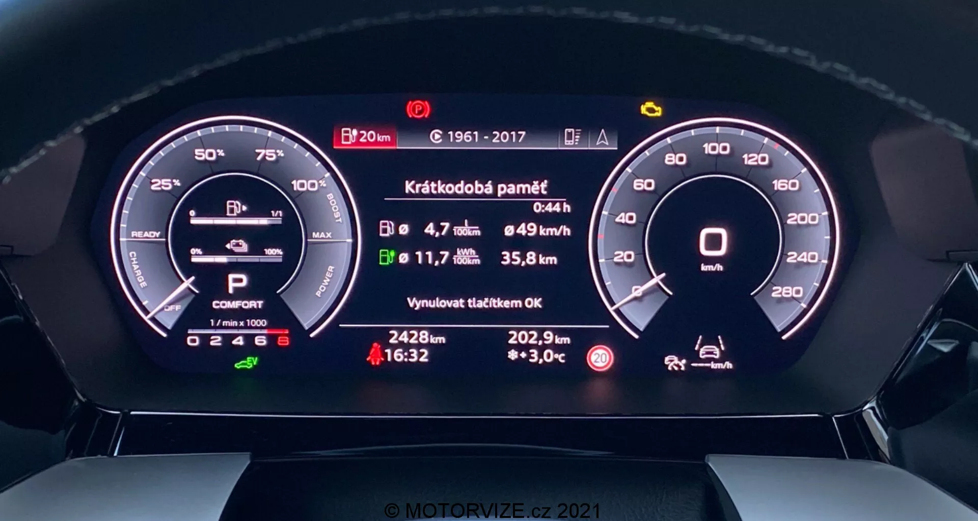 Vue rapprochée du tableau de bord numérique de l'Audi A3 2020 Sportback, vue depuis le siège du conducteur. La perspective de face montre des affichages numériques détaillés d'un compte-tours, d'un indicateur de batterie, de la sélection de la vitesse, du mode de conduite, de la vitesse moyenne, de la consommation de carburant, de la distance avant le réservoir vide, de la température extérieure et d'un message d'état concernant l'entretien récent. Le design moderne intègre des éléments numériques et analogiques pour une expérience à la fois high-tech et intuitive.