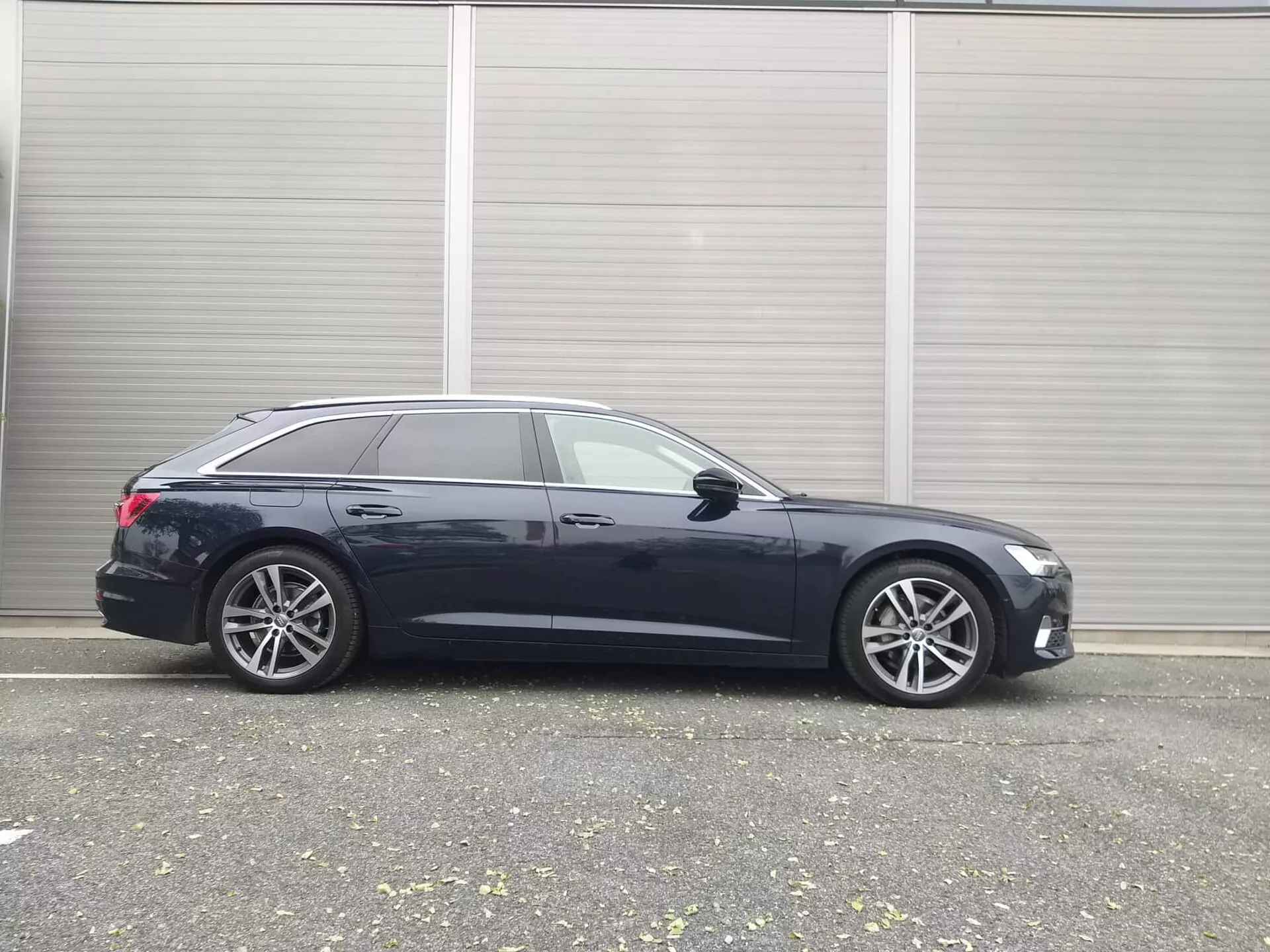 Profil latéral de l'Audi A6 break 2018, présentant un design élégant, des fonctionnalités technologiques avancées et des jantes en alliage premium, garée dans un cadre industriel