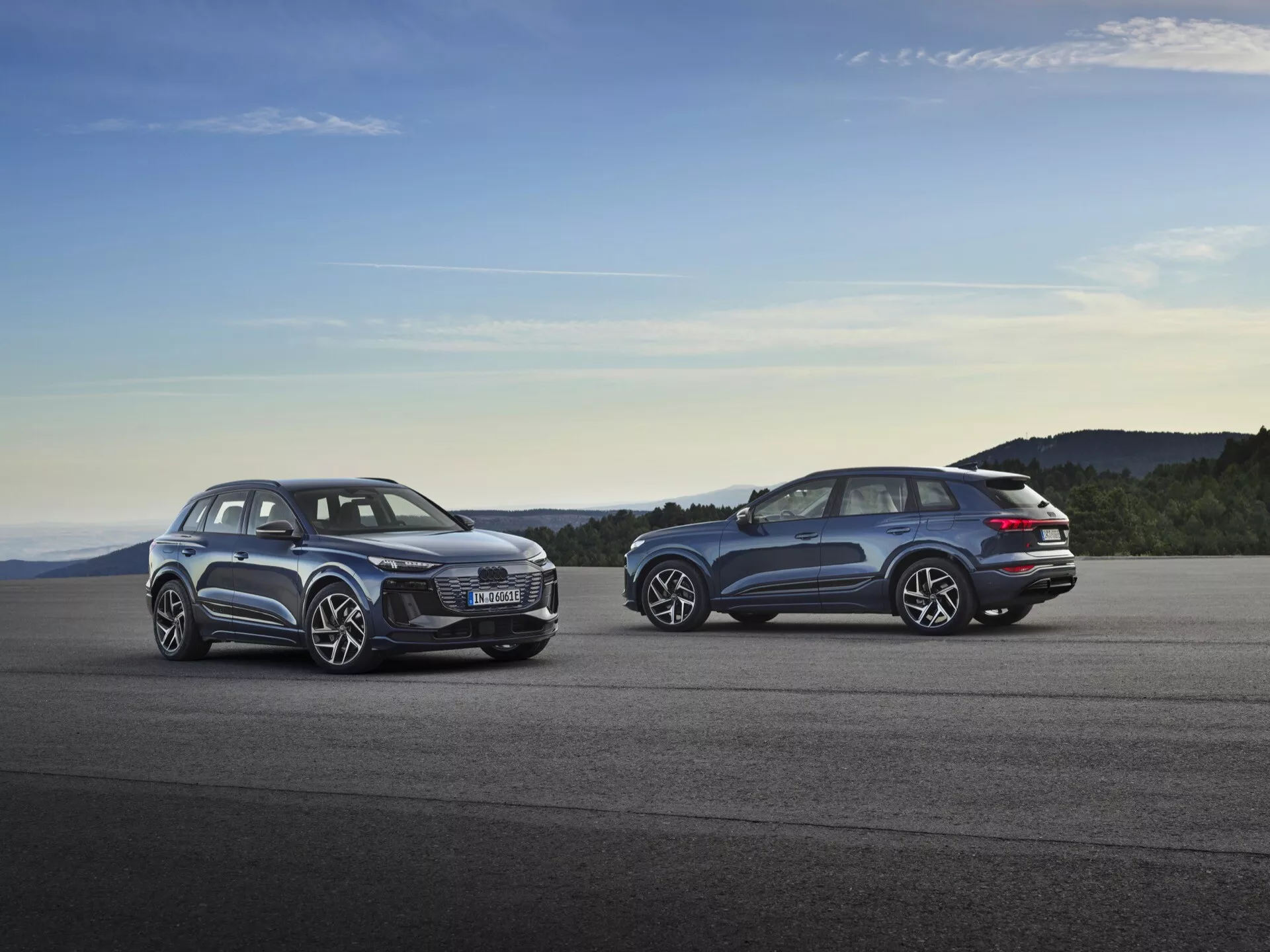 Audi Q6 e-tron 2024 (GF) garé au coucher du soleil montrant son design aérodynamique élégant, ses phares à LED futuristes, son intérieur spacieux, ses grandes roues en alliage et sa chaîne cinématique électrique avancée.