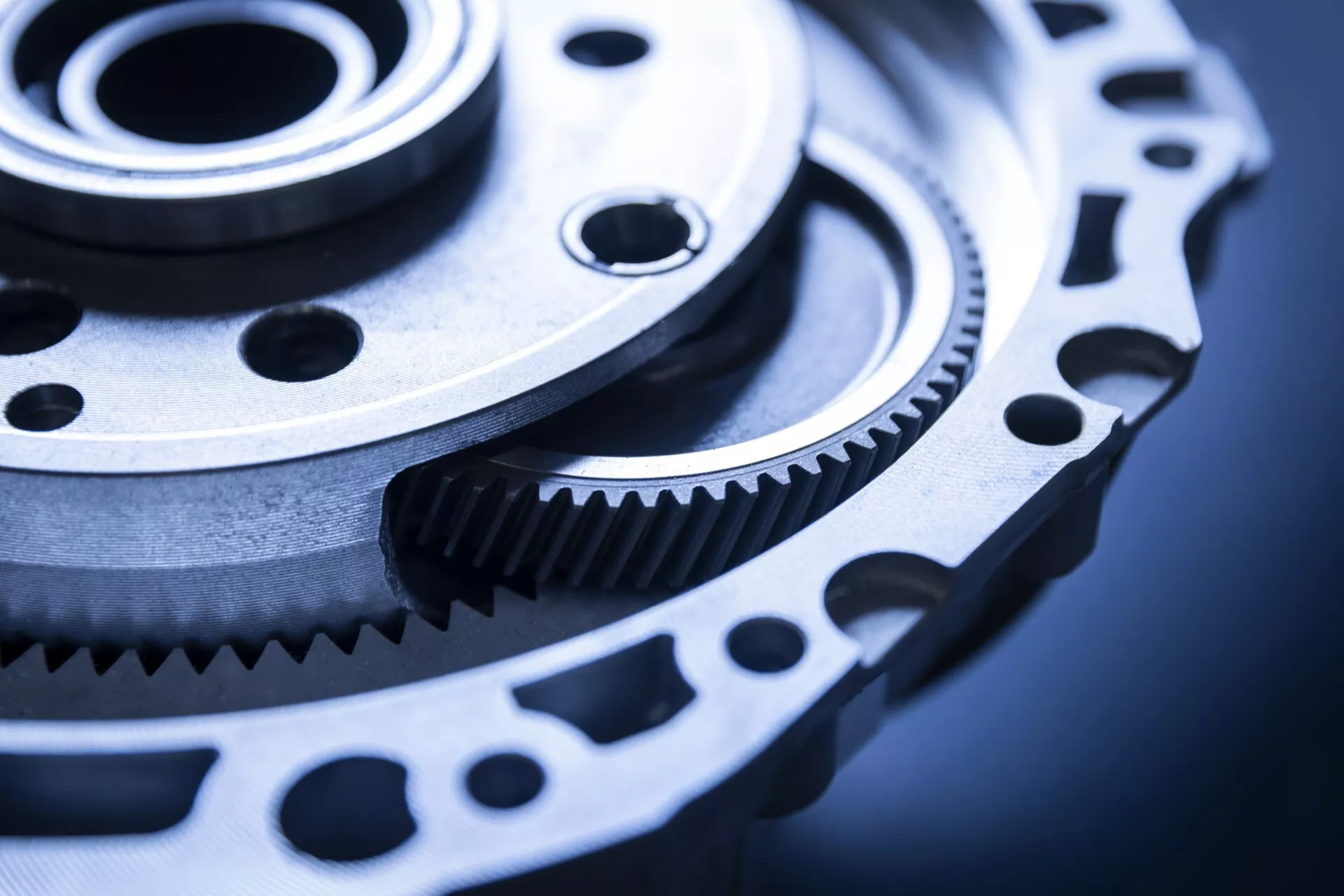 Gros plan d'un engrenage et d'une roue dentée de précision, probablement destinés à une utilisation automobile, mettant en avant un usinage fin et un potentiel de transmission de puissance dans un cadre industriel froid