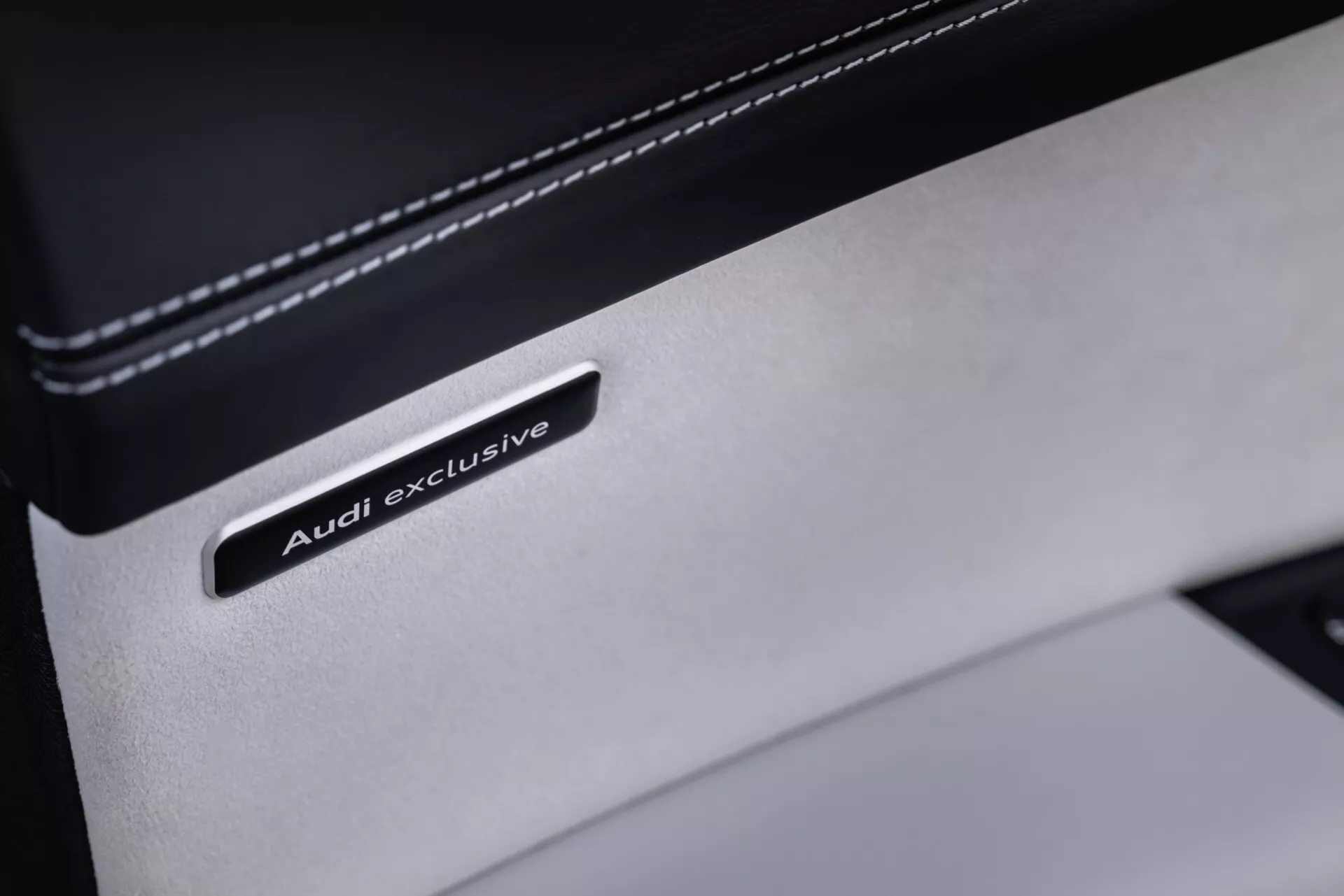 Gros plan sur le badge Audi exclusive sur détail en cuir haut de gamme dans l'intérieur de l'Audi Q8 2023 (4M-Facelift), mettant en avant la personnalisation de luxe et la qualité du matériel