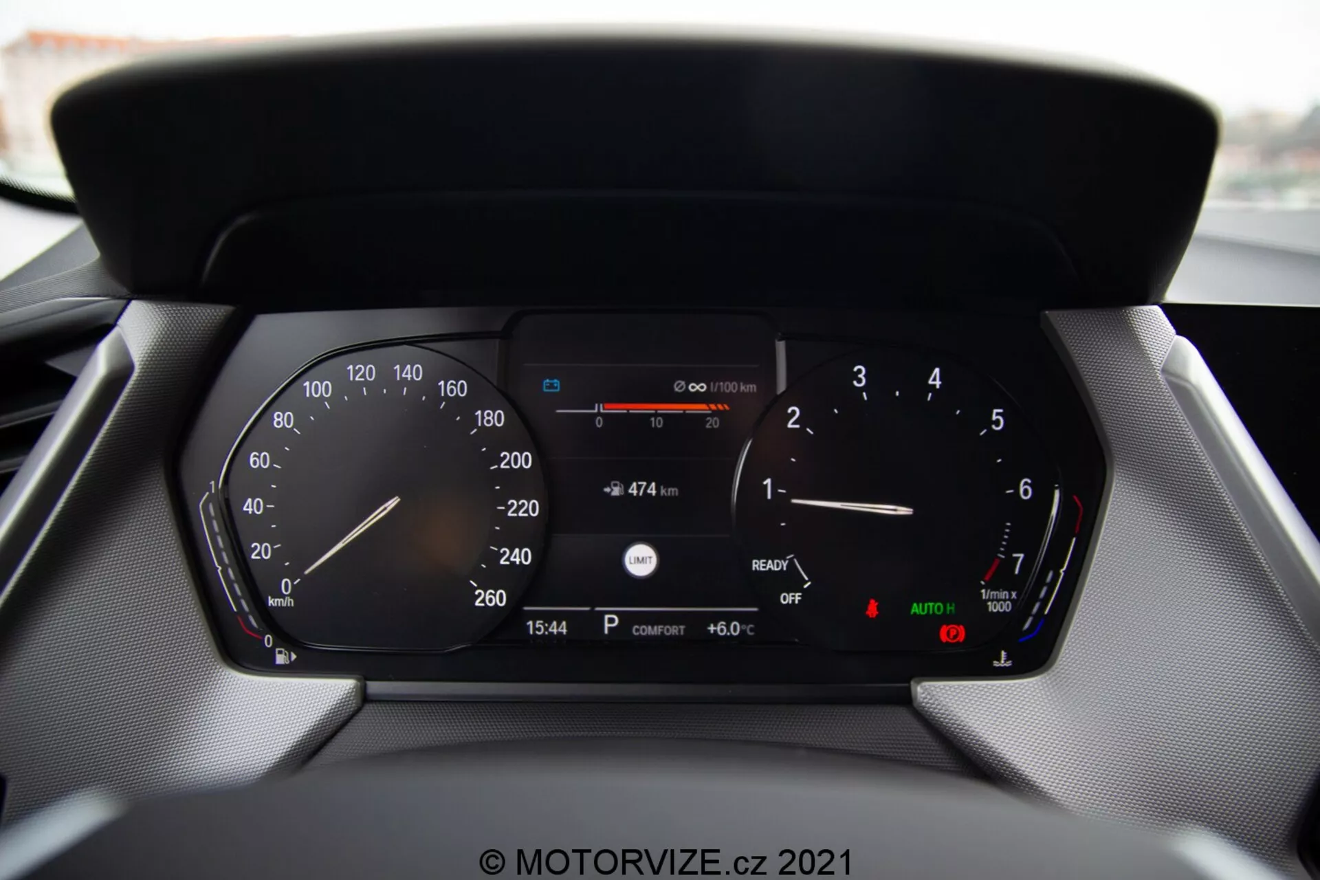 Vue rapprochée du tableau de bord numérique d'une voiture moderne BMW Série 1 2019 (BMW 116i), affichant des lectures détaillées, notamment le compteur de vitesse, le tachymètre, la jauge de carburant, le thermomètre, l'affichage numérique de la vitesse, la distance restante avec le carburant actuel, l'heure (15:54), la température extérieure (6.0°C) et les indicateurs pour les phares automatiques et le frein de stationnement.