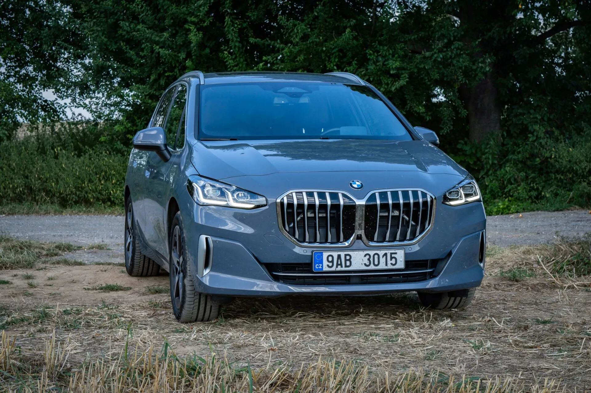 SUV BMW Série 2 Active Tourer bleu sous un angle avant de trois quarts montrant la calandre rénale iconique, les phares LED, le pare-chocs avant avec feux de brouillard et entrées d'air, jantes en alliage, et une partie de sa carrosserie latérale bleu métallisé