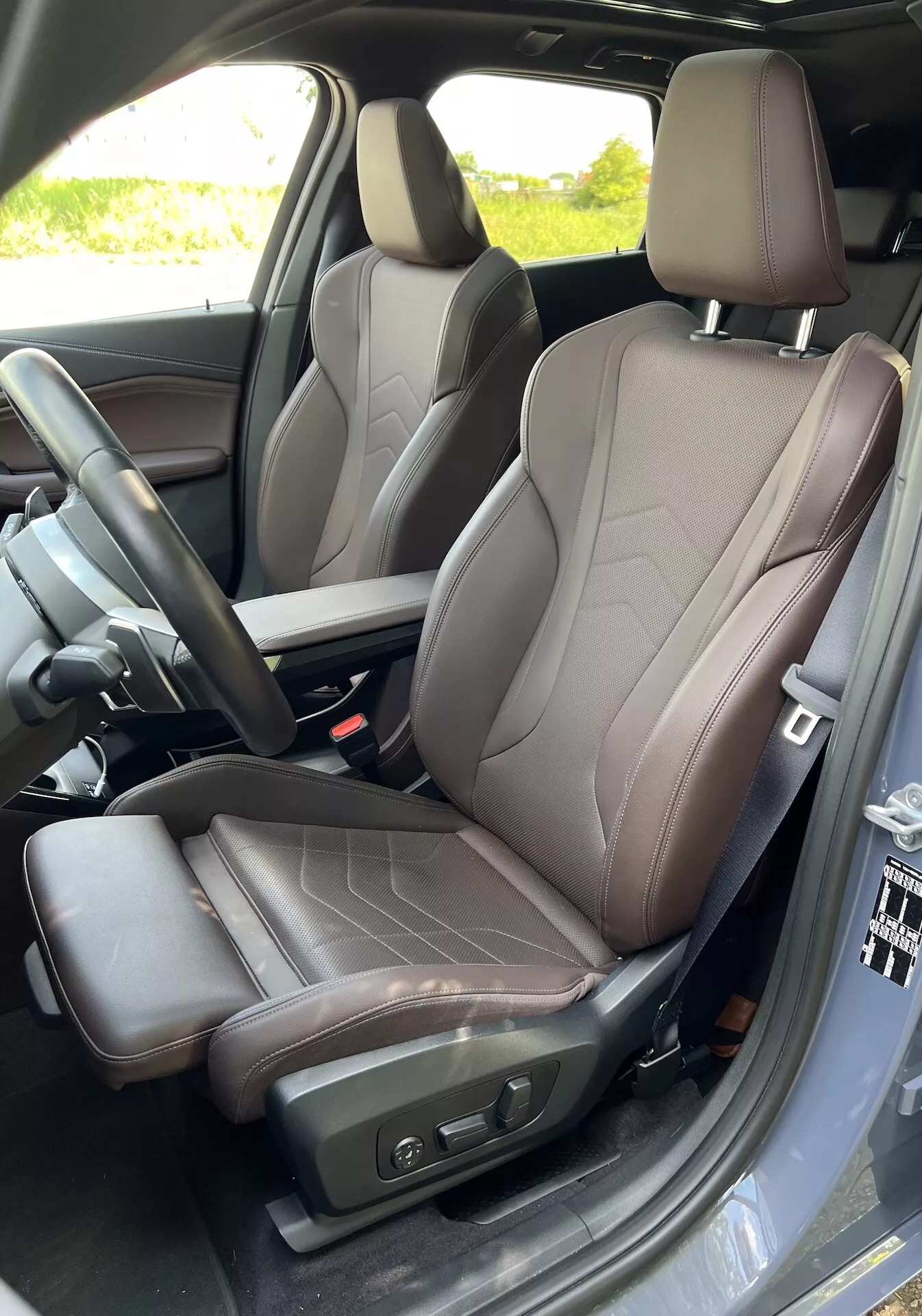 Vue intérieure du siège conducteur de la BMW Série 2 Active Gran Tourer 2022 mettant en avant un design de siège moderne avec cuir bicolore, commandes de réglage électrique et partie visible de la console centrale