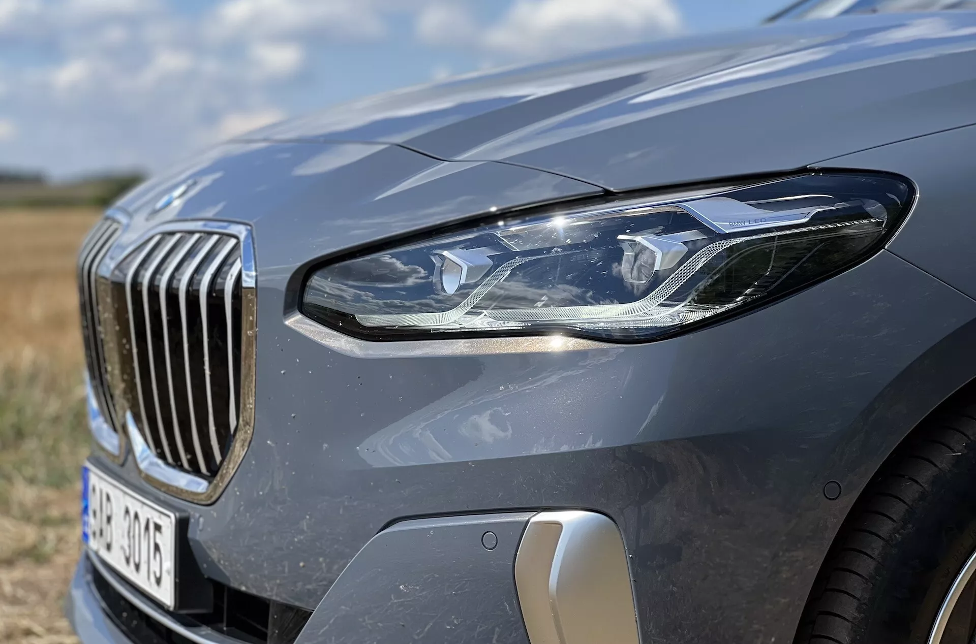Vue rapprochée du quart avant gauche de la BMW Série 2 Active Tourer 2022 mettant en avant l'assemblage des phares LED, la grille à barres verticales et les caractéristiques aérodynamiques
