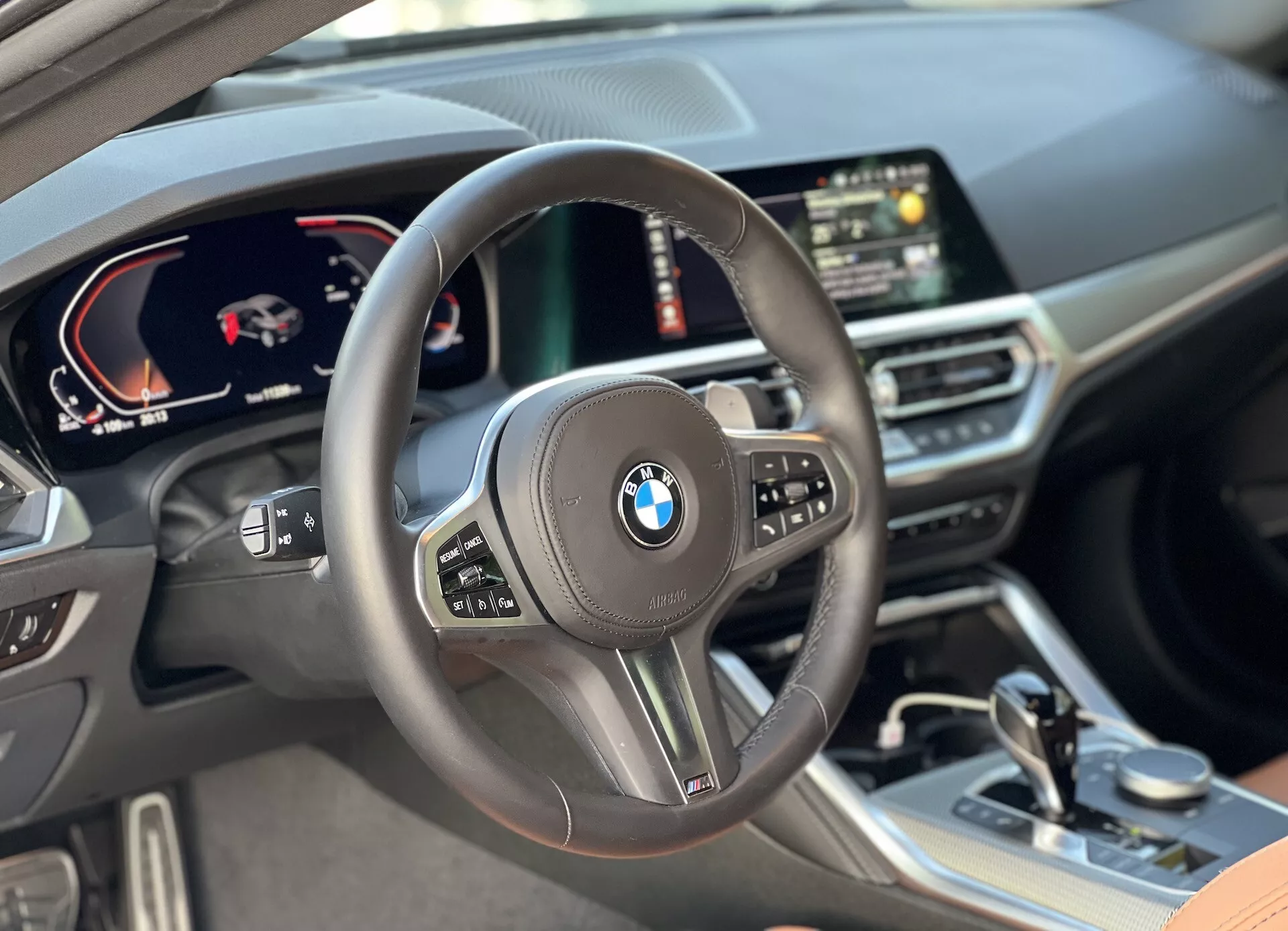 Vue intérieure de la BMW Série 2 Coupé 2022 depuis la perspective du conducteur, avec un volant central doté de commandes multifonctions, un tableau de bord numérique affichant le tachymètre et le compteur de vitesse, un écran central numérique avec navigation GPS, et des matériaux haut de gamme incluant des surfaces en cuir et des éléments de finition soigneusement conçus dans l'habitacle.