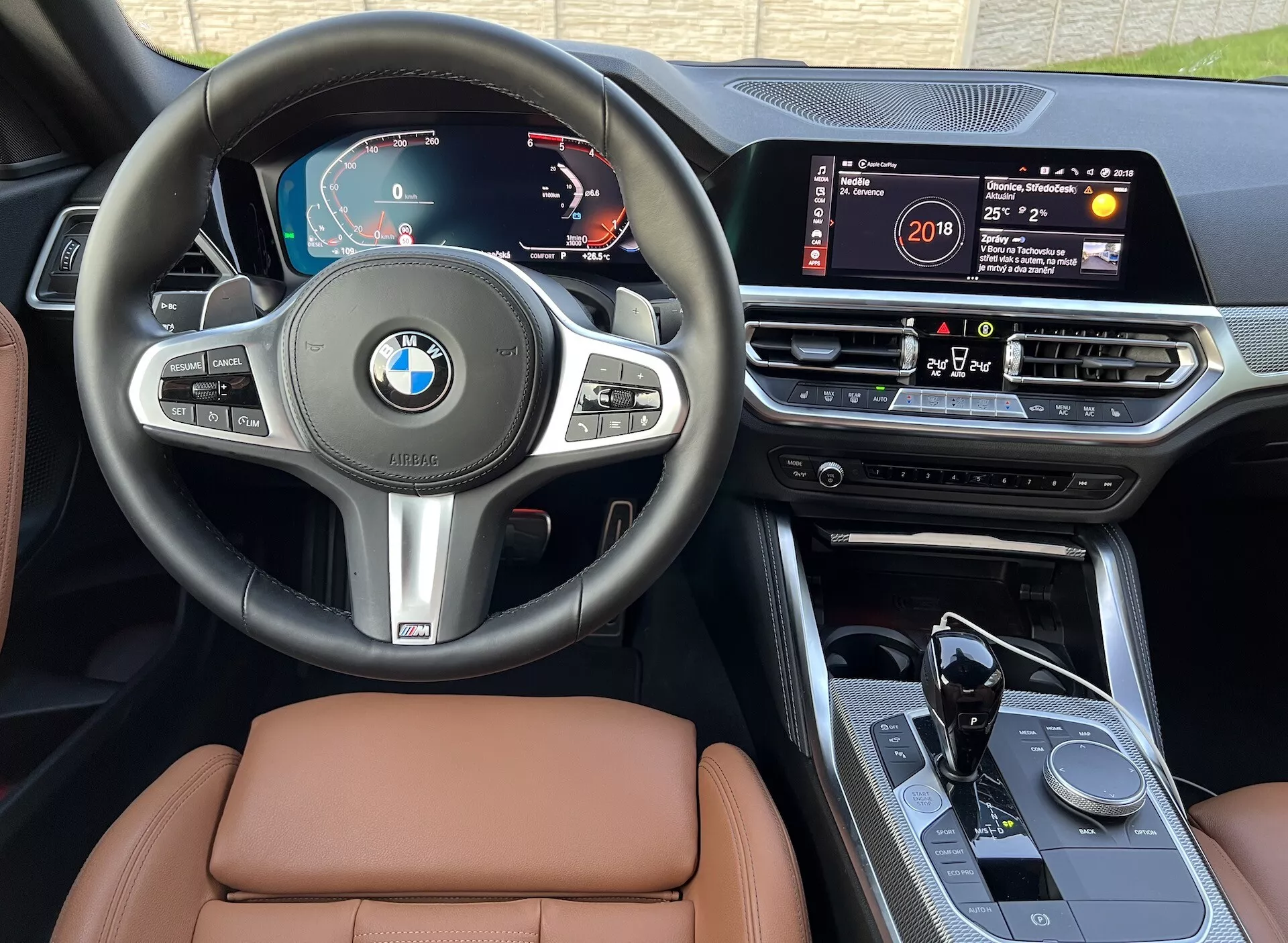 Vue intérieure de la BMW Série 2 2022 montrant le tableau de bord, le volant et la console centrale. Les caractéristiques incluent un tableau de bord numérique, un volant multifonction, un grand système d'infodivertissement à écran tactile, un bouton de commande rotatif sur la console centrale, un levier de vitesse automatique au design sportif et des sièges en cuir de haute qualité, le tout vu de la perspective du siège du conducteur en lumière naturelle.