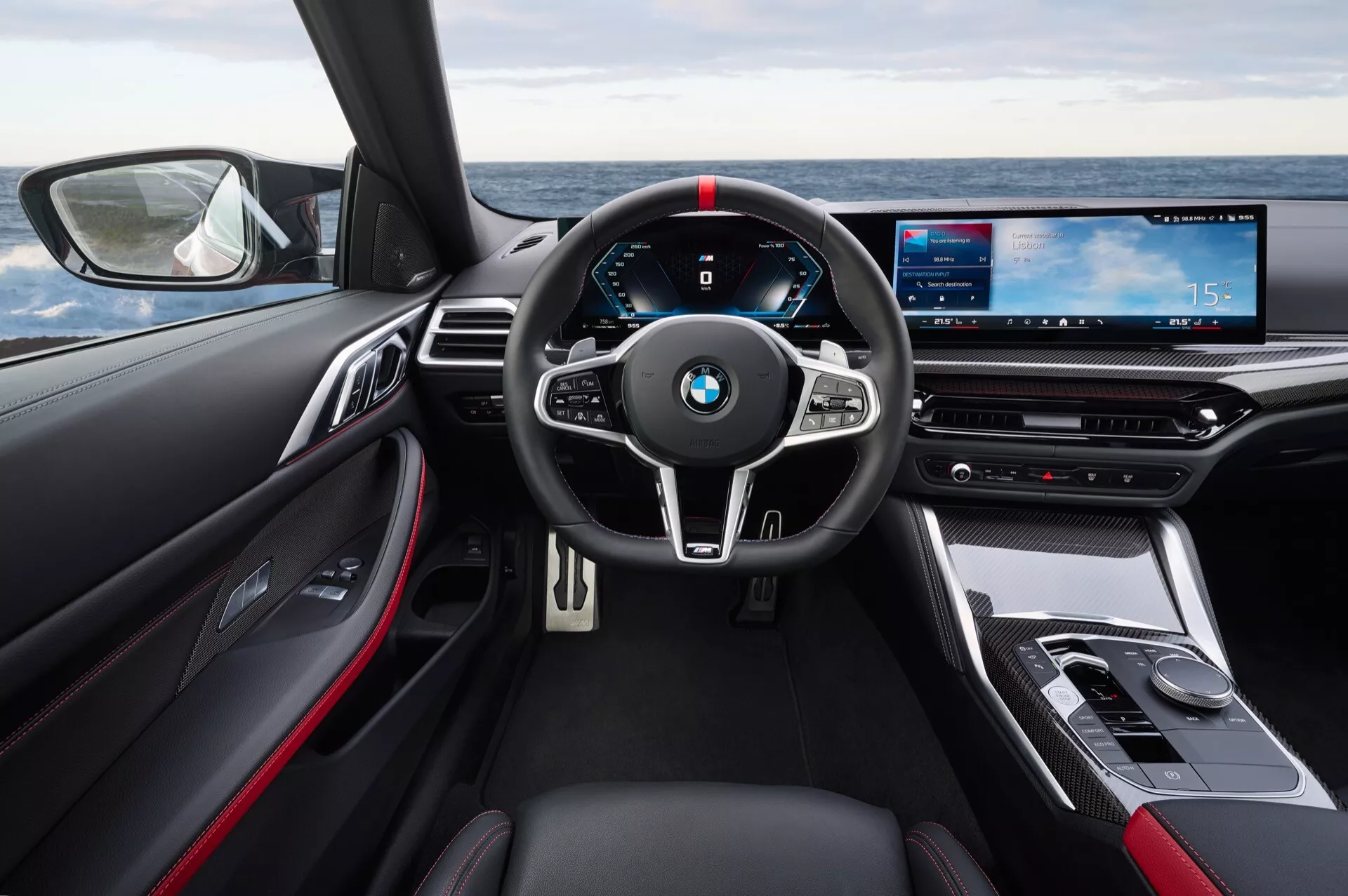Vue intérieure de la BMW Série 4 2024 (G22-G23-G26-G82-G83 facelift) centrée sur le volant et le tableau de bord numérique depuis le siège du conducteur, mettant en avant les technologies avancées et les caractéristiques de luxe