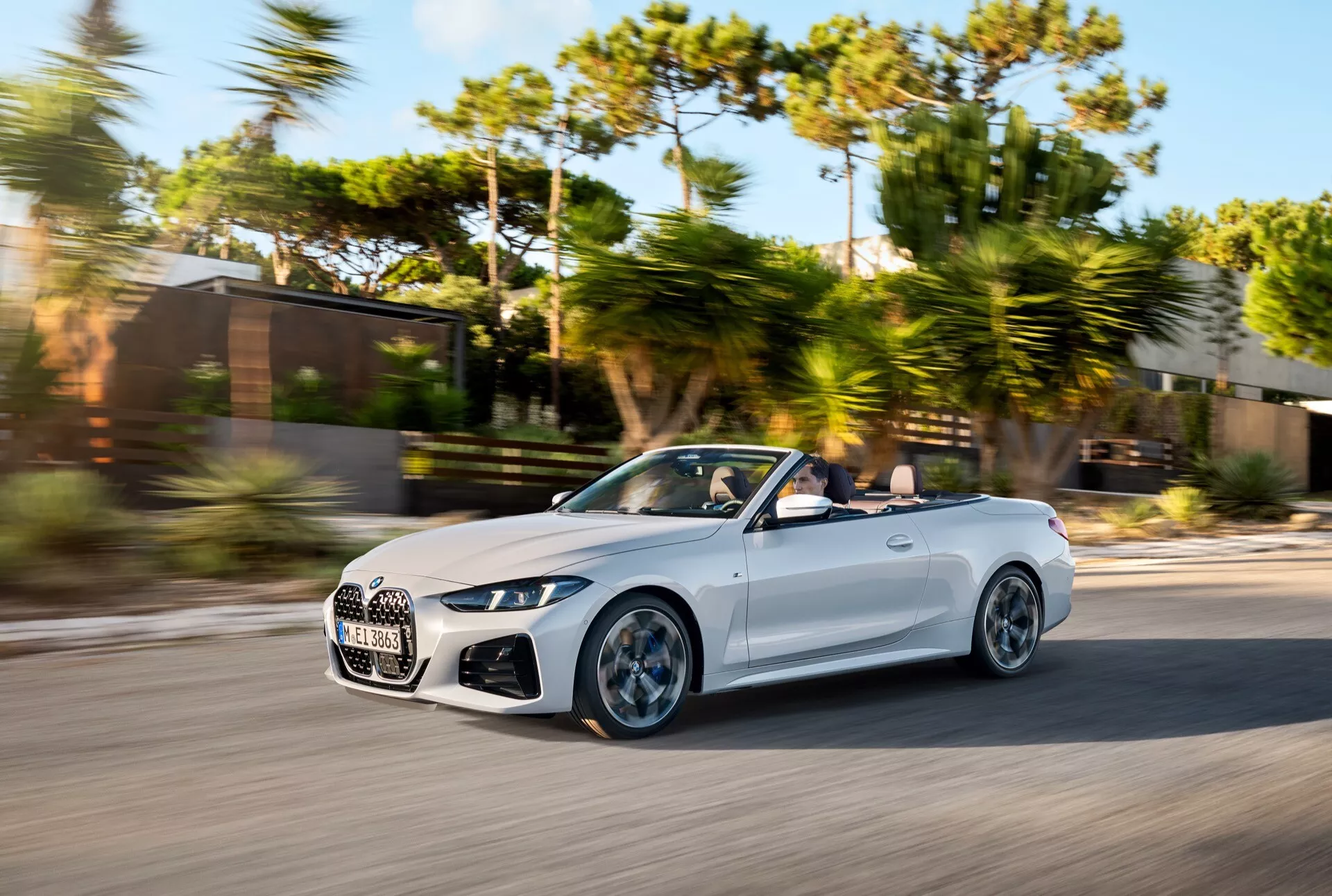 BMW Série 4 Cabriolet 2024 (Lifting G22-G23-G26-G82-G83) en mouvement, capturée d'un angle avant de trois quarts mettant en évidence l'aérodynamisme, la grille premium et les phares LED lors d'une journée ensoleillée avec flou d'arrière-plan.