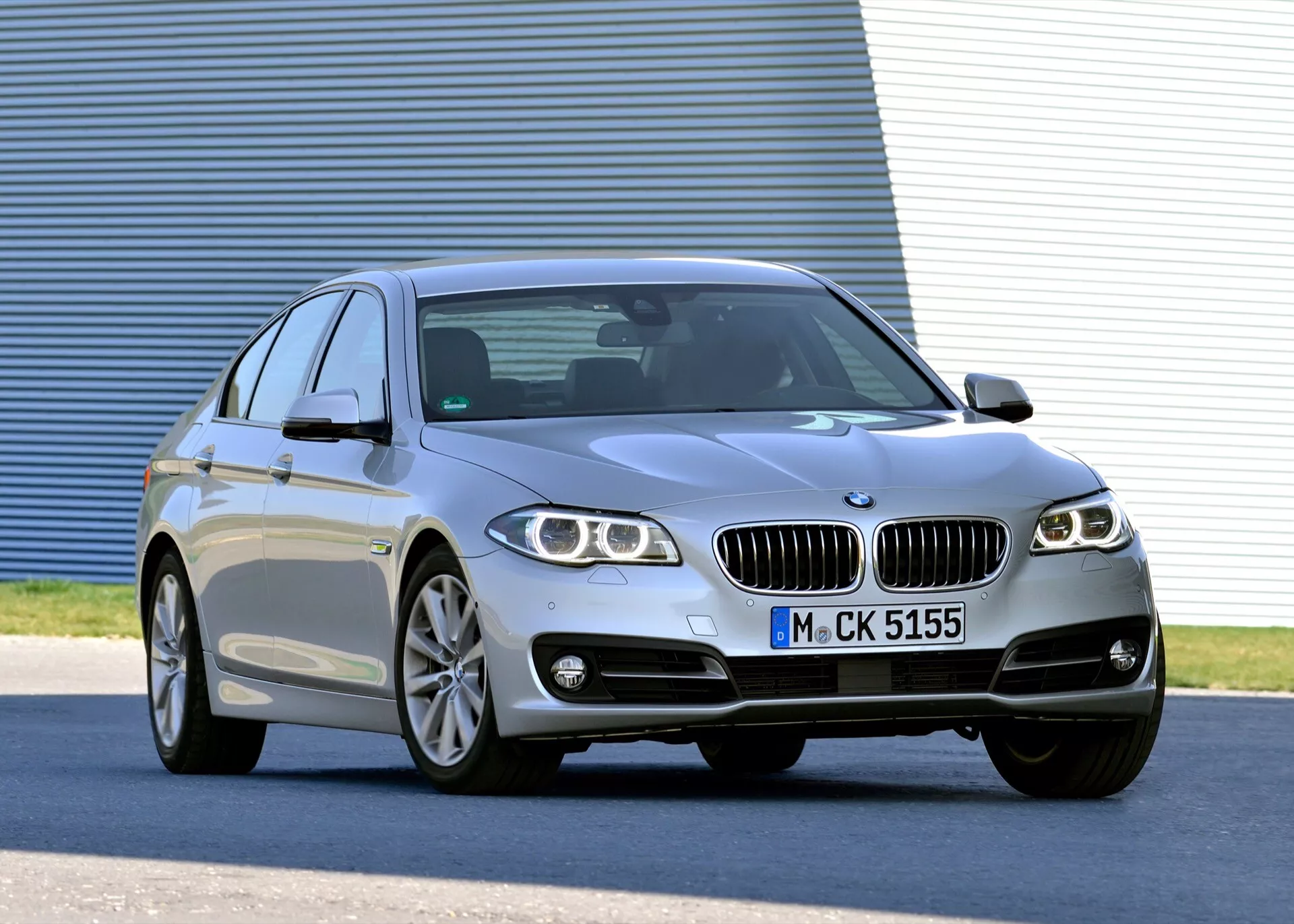 Berline de luxe argentée BMW Série 5 (F07-F10-F10M-F11-Restylage) 2013 en vue de trois quarts avant montrant des phares à LED, des jantes en alliage, une calandre à double rein, une carrosserie sportive quatre portes avec ligne de toit façon coupé et des fonctionnalités technologiques avancées
