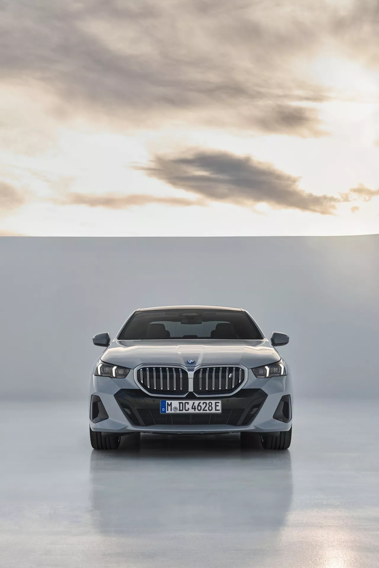 Vue frontale de la BMW Série 5 2023 (G60-G61) montrant la calandre en forme de double rein, les phares LED avec feux de jour, les lignes de capot contourées, l'emblème du fabricant, le pare-chocs avant orienté performance avec de grandes prises d'air, d'éventuels capteurs intégrés pour l'assistance au conducteur, et une finition polie sur un fond de studio propre