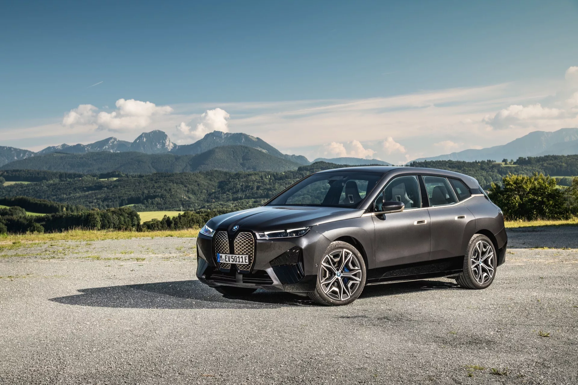 SUV de luxe BMW iX (i20) 2021 garé en extérieur mettant en avant son design moderne avec un arrière-plan montagneux pittoresque, soulignant la grille avant, les phares LED et le corps élégant et aérodynamique