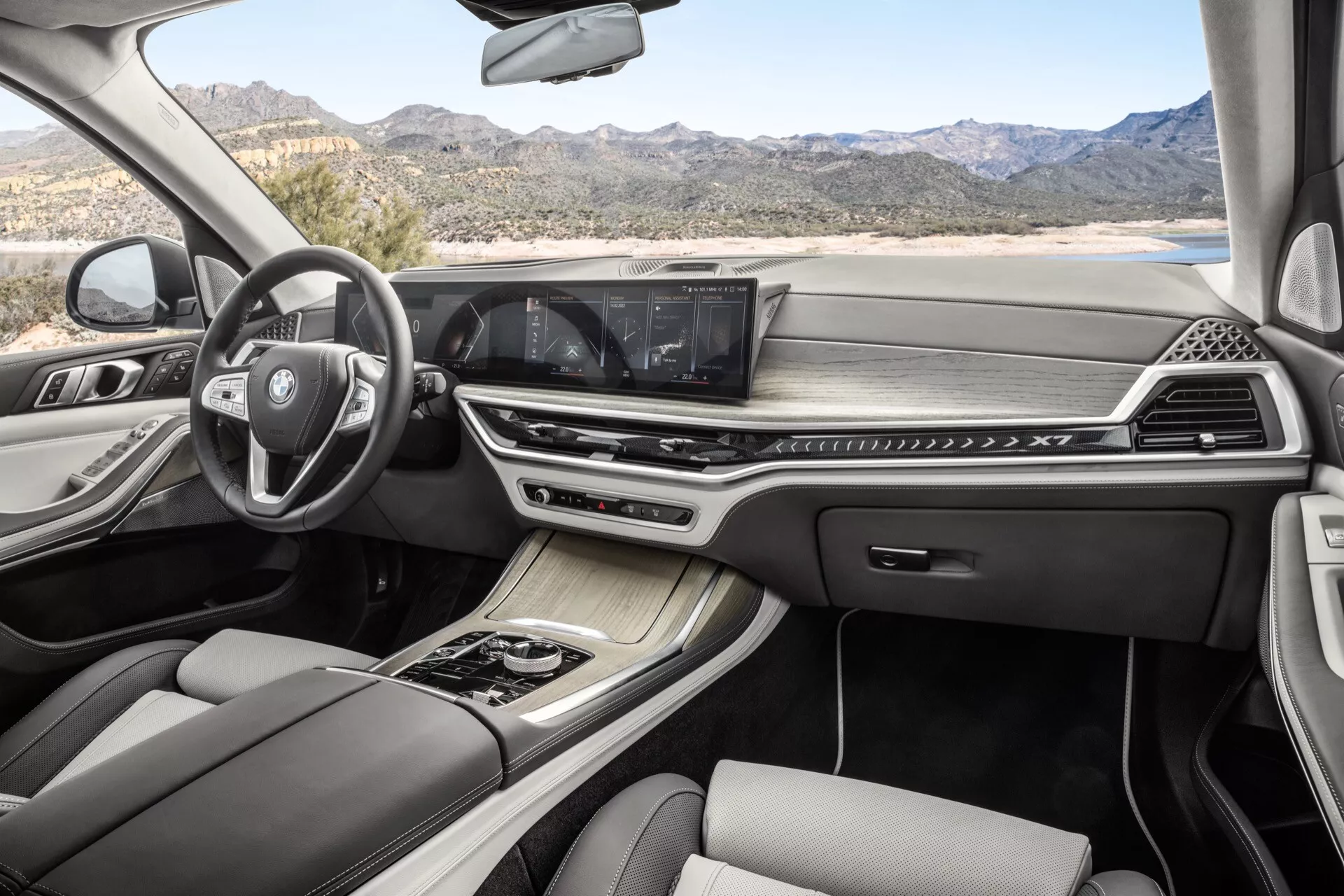 Intérieur du BMW X7 2022 (G07-facelift) avec volant multifonction, système d'infodivertissement avancé avec écran tactile, contrôle de climatisation bi-zone, levier de vitesse automatique élégant, sièges en cuir de luxe avec coutures contrastantes et toit panoramique