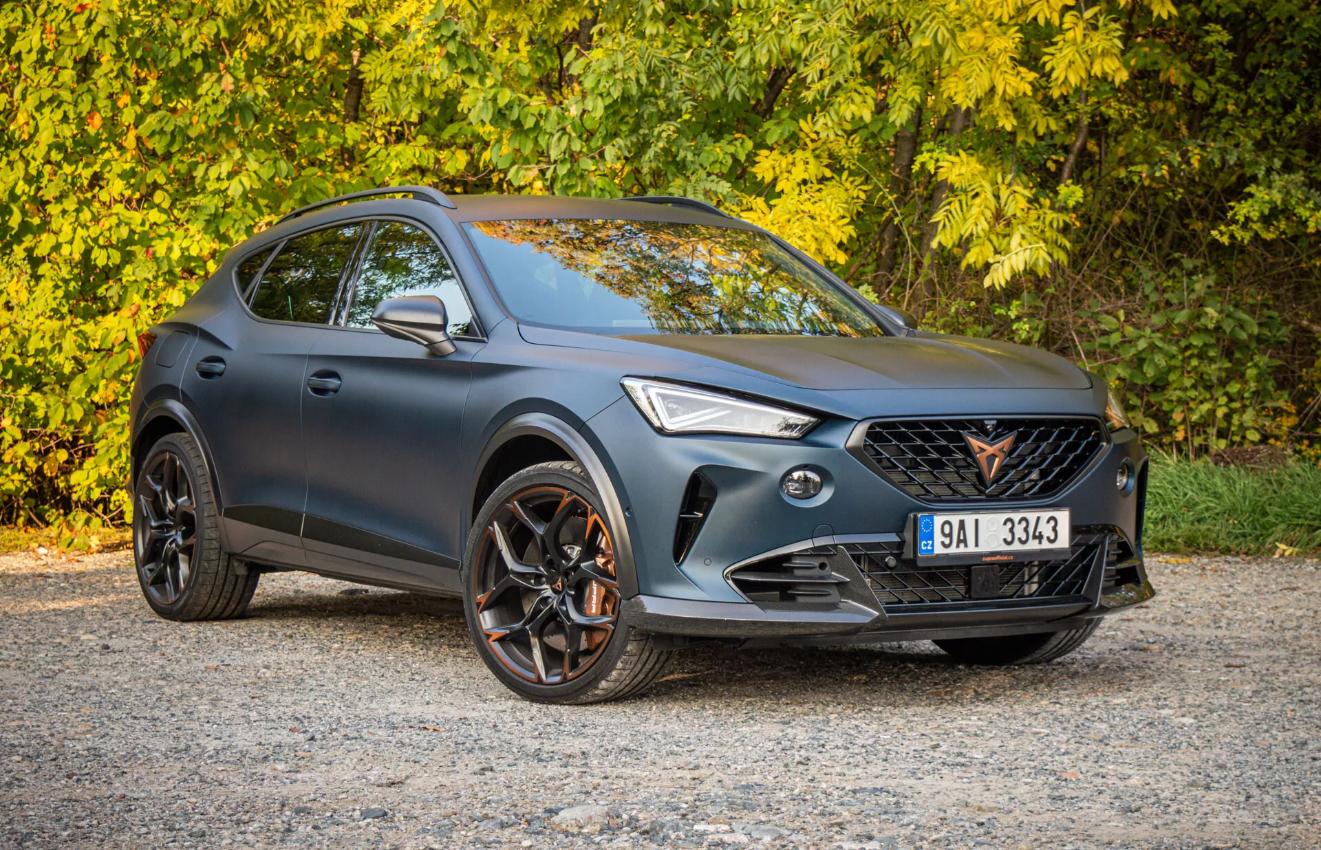 SUV crossover Cupra Formentor 2020 garé à l'extérieur, montrant une perspective frontale aux trois quarts avec un accent sur le design sportif, la façade avant avec phares LED et grille, profil latéral avec roues en alliage à multiples branches et capacité potentielle tout-terrain