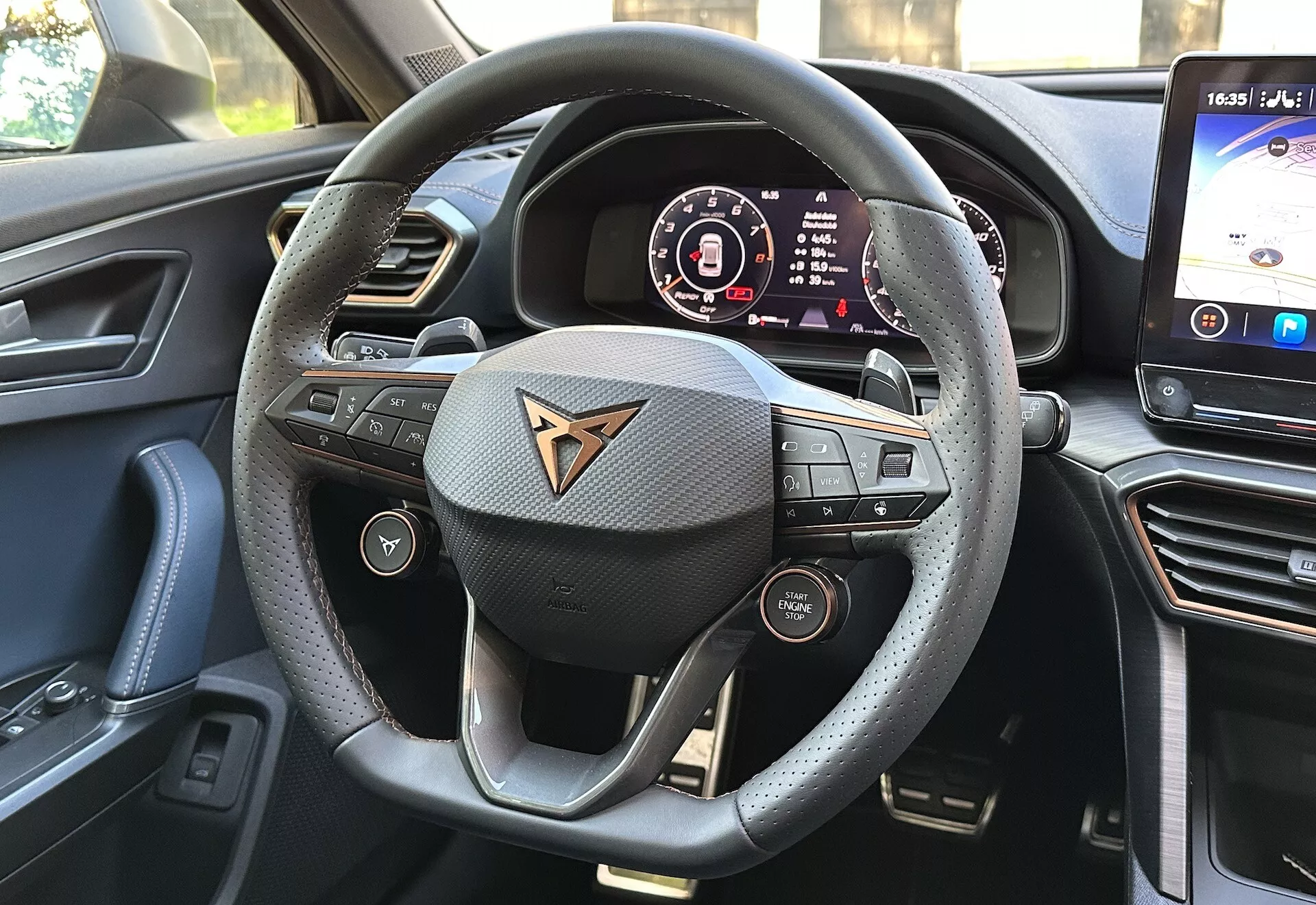 Vue intérieure du cockpit de la Cupra Formentor 2020, avec un volant tactile portant le logo de la marque, un tableau de bord numérique et un grand système d'infodivertissement tactile.