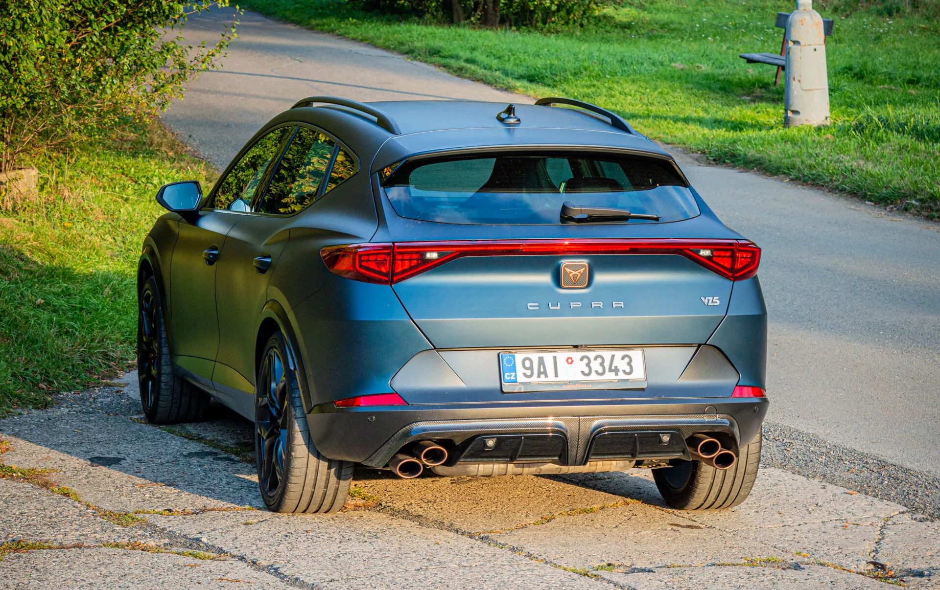 Vue arrière d’un SUV Cupra Formentor VZ5 2020 avec feux arrière LED, système d’échappement quadruple, diffuseur arrière et pare-chocs sportifs, jantes à multi-branches et finition mate anthracite, photographié dans un cadre suburbain en plein jour