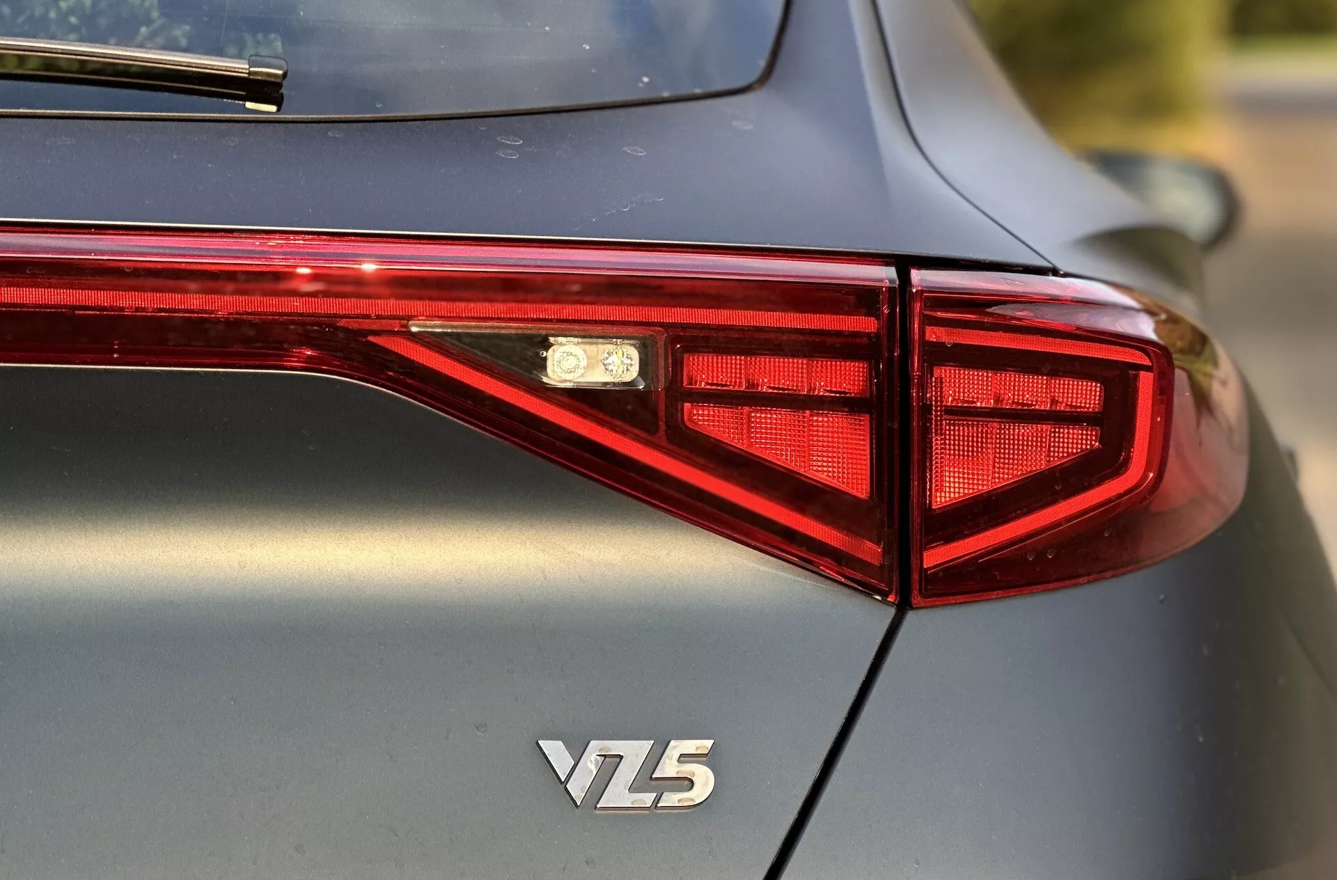 Vue arrière d'une Cupra Formentor VZ5 de 2020 mettant en avant le design des feux arrière LED, l'emblème et la carrosserie métallique de haute qualité, prise depuis un angle de trois quarts avec une faible profondeur de champ