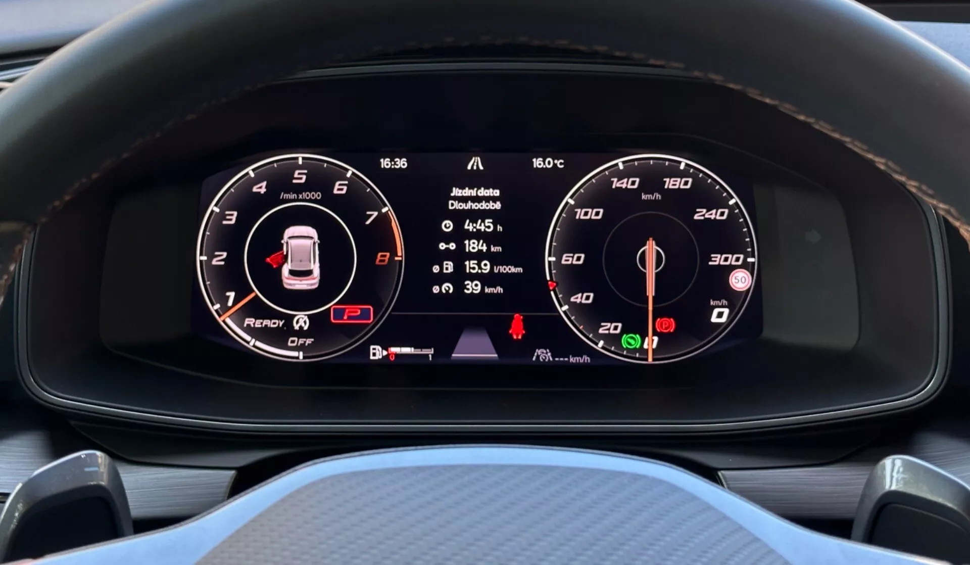 Vue rapprochée du tableau de bord numérique du Cupra Formentor 2020 affichant le compte-tours, le schéma du véhicule avec avertissement et le compteur de vitesse stationnaire du point de vue du conducteur