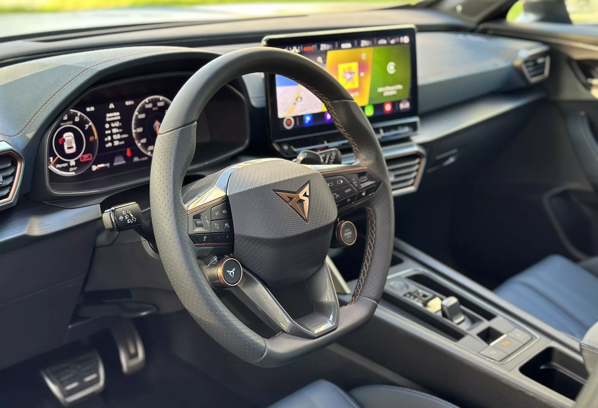 Vue intérieure du Cupra Formentor 2020 se concentrant sur la perspective du conducteur avec une vue claire du volant multifonction, du tableau de bord numérique et d'une partie du système d'infodivertissement, soulignée par un design moderne et des caractéristiques de technologie avancée