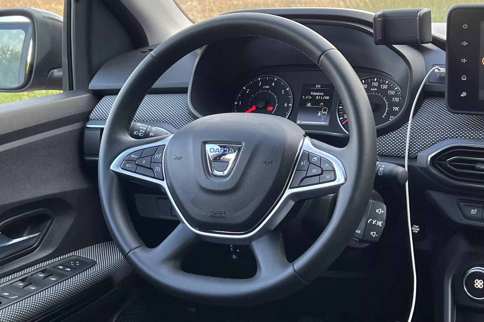 Vue intérieure du Dacia Jogger 2022 depuis le siège conducteur, se concentrant sur le volant avec commandes multifonctions et le tableau de bord avec système d'infodivertissement