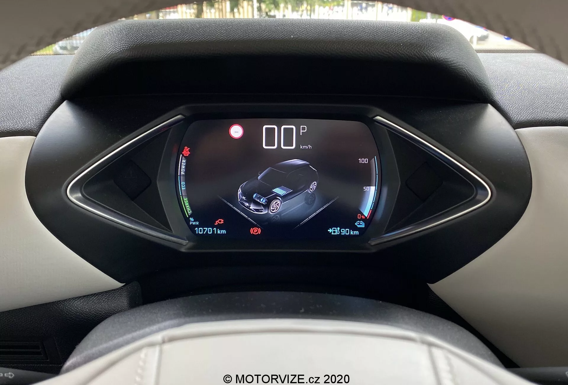 Vue intérieure du DS Automobiles DS-3 Crossback E-Tense 2019 depuis la perspective du conducteur, mettant en évidence un tableau de bord numérique avec un capot asymétrique unique. L'affichage montre les jauges de batterie et de température, un graphique central de la voiture avec des icônes de sécurité et d'assistance, et des informations sur les données du trajet et les relevés de l'odomètre, indiquant des fonctionnalités modernes et de haute technologie à l'intérieur. Image claire et nette, marque d'eau MOTORVIZE.cz 2020.