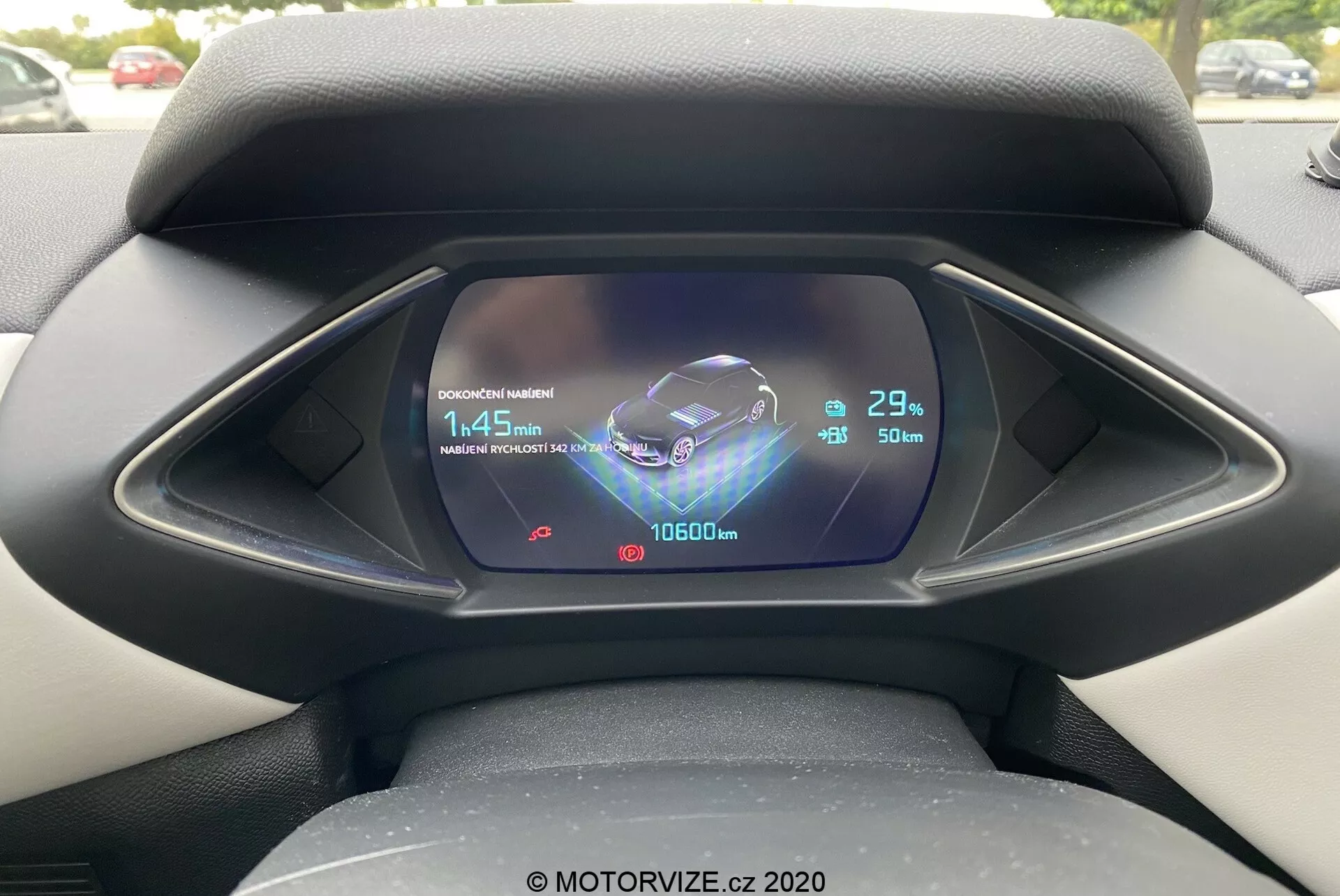 Vue rapprochée du tableau de bord numérique depuis la perspective du conducteur à l'intérieur d'une DS Automobiles DS 3 2019 (DS 3 Crossback E-Tense). L'écran LCD/TFT affiche des graphiques complexes, notamment une représentation animée du véhicule, un symbole Bluetooth, une indication de temps de charge de 1:45 min avec une charge de batterie de 29%, une température extérieure de 23°C, un odomètre avec une lecture de 10600 km et une jauge de carburant presque pleine avec une estimation de portée de 50 km.