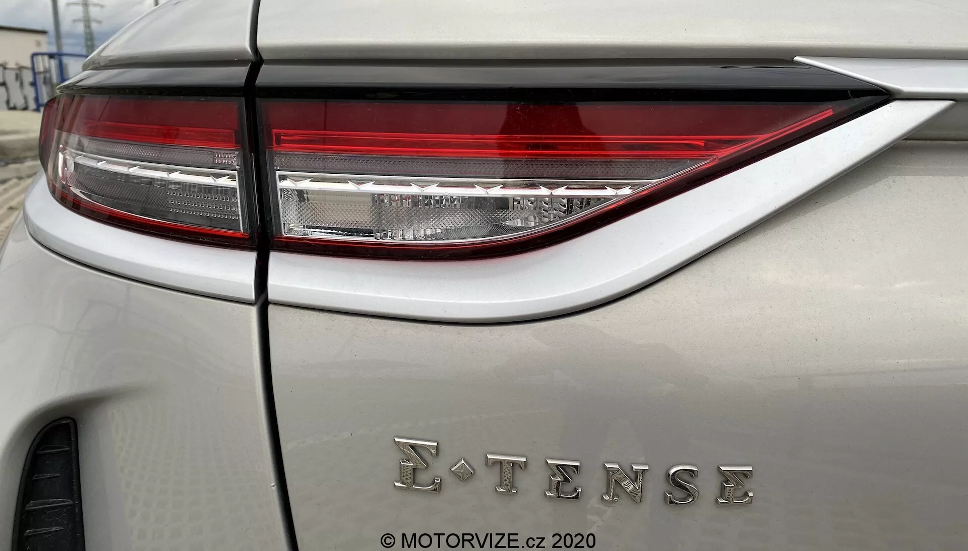 Gros plan détaillé du panneau arrière du DS Automobiles DS-3 2019 (DS-3 Crossback E-Tense) montrant un ensemble de feux arrière LED modernes et sophistiqués et un badge E-TENSE indiquant une technologie électrique ou hybride. La voiture présente une couleur de carrosserie neutre avec une finition mate ou satinée.