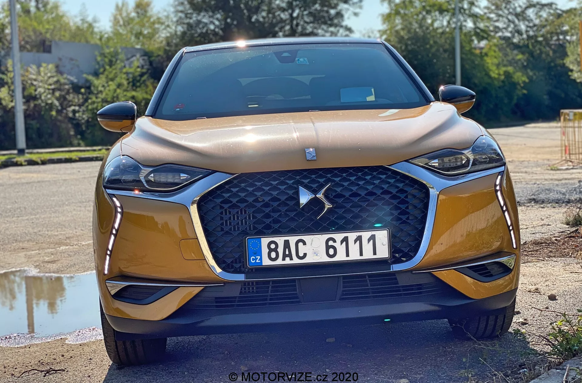 2019 DS Automobiles DS-3 Crossback en mouvement sur une route pittoresque, montrant son design audacieux, ses courbes élégantes et ses caractéristiques sophistiquées