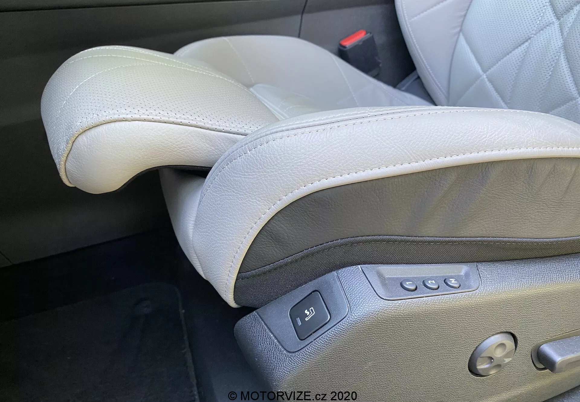 Gros plan de l'intérieur de la DS Automobiles DS-7 2018 (DS-7 Crossback), mettant l'accent sur le luxueux siège conducteur en cuir gris clair situé à gauche dans une configuration de conduite à gauche. Les caractéristiques visibles incluent un cuir de haute qualité avec des coutures, un appuie-tête réglable, des commandes électriques du siège avec plusieurs boutons pour le glissement, l'inclinaison, le réglage de la hauteur et le support lombaire, ainsi qu'un bouton de réglage de la mémoire et une boucle de ceinture de sécurité visible, mettant en valeur le design premium et ergonomique.