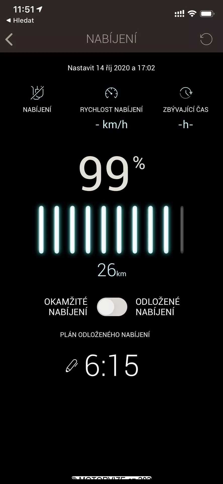 Capture d'écran affichant l'état de charge d'un véhicule électrique sur une application mobile ou une interface de système d'infodivertissement. En haut, une icône de batterie et le mot 'NABIJENI' indiquent la charge en tchèque. En dessous, un réglage pour le 14 octobre 2020 à 17h02 est affiché. La barre de statut de la batterie est presque complètement chargée à 99%, avec un indicateur de portée de 26 km. Deux boutons, étiquetés 'Charge Immédiate' et 'Charge Différée', permettent de contrôler les temps de charge. En bas, une horloge affiche 6h15 pour la charge différée. L'interface présente un design épuré avec un fond noir et des textes blancs et verts, idéal pour améliorer la lisibilité.