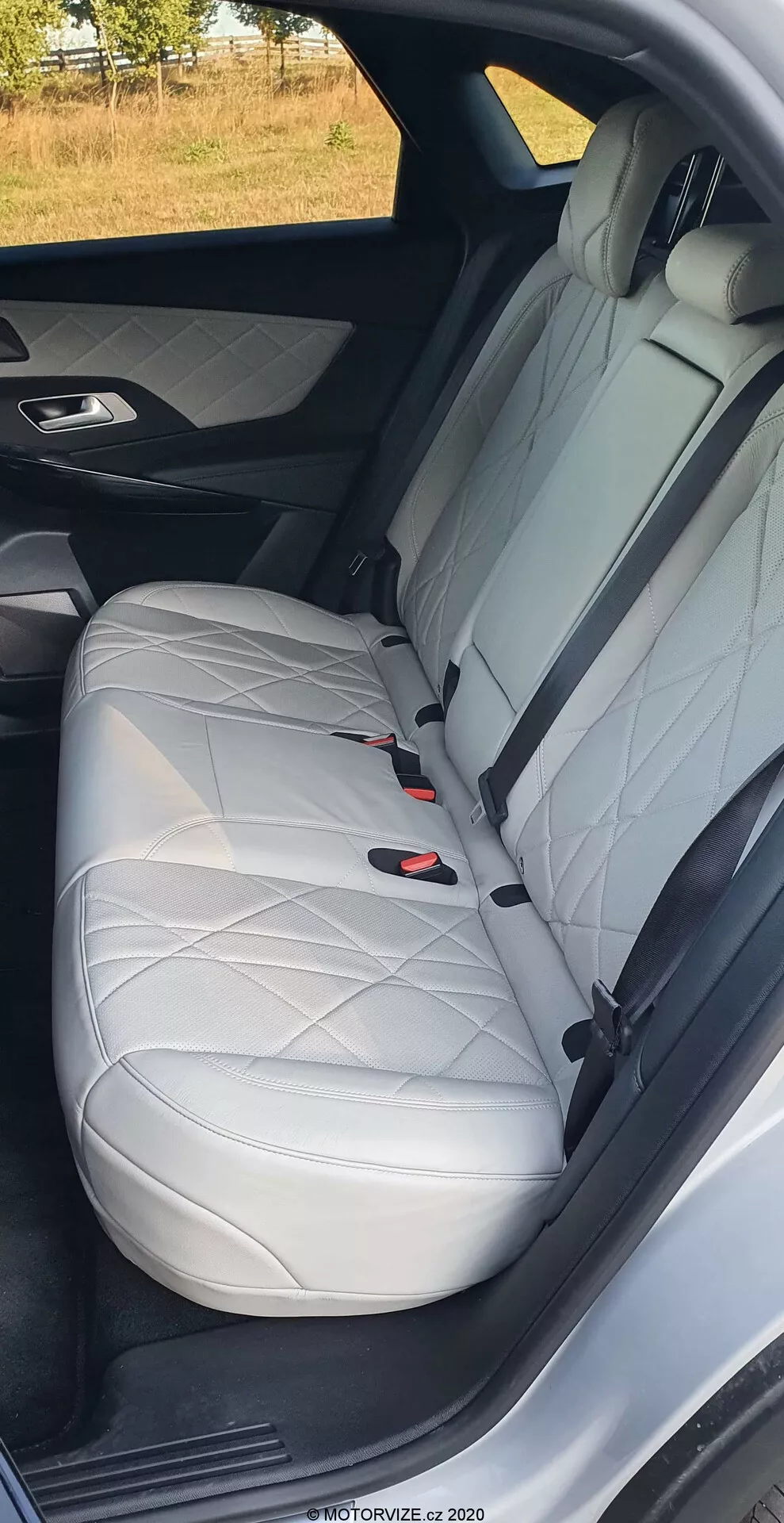 Gros plan sur le siège passager arrière du DS Automobiles DS-7 2018, montrant le cuir blanc avec des coutures en losange, l'appuie-tête, la ceinture de sécurité à trois points et le système LATCH, mettant en valeur le design intérieur luxueux et les caractéristiques de sécurité de la voiture