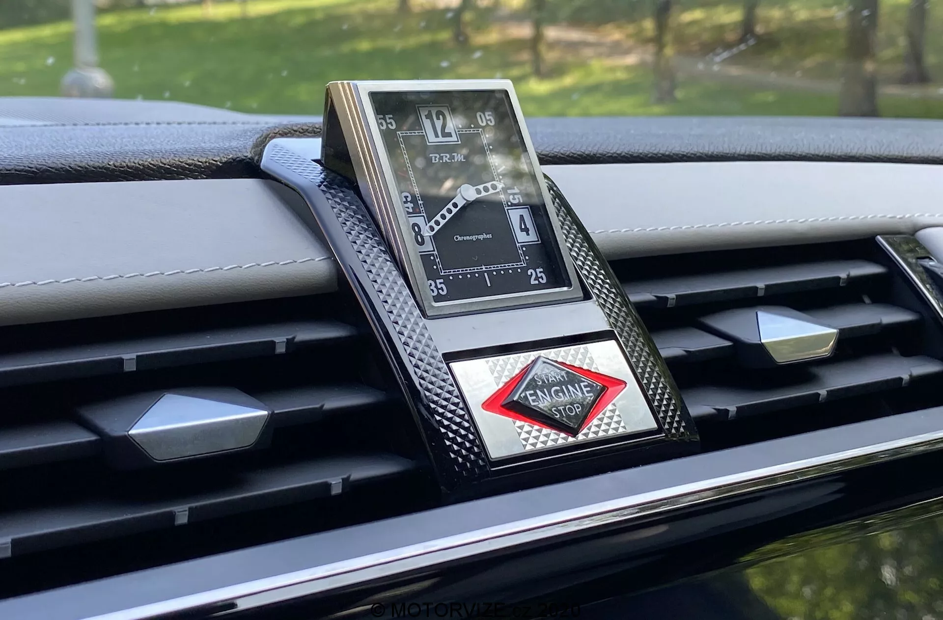 Gros plan sur l'horloge analogique luxueuse intégrée dans le tableau de bord de la DS-7 Crossback 2018, présentant un design sophistiqué avec chiffres romains, finition métallique et logo en forme de diamant. Le tableau de bord présente des accents en fibre de carbone et des coutures détaillées, mettant en valeur l'artisanat haut de gamme et les matériaux avancés de cet intérieur de voiture de luxe.