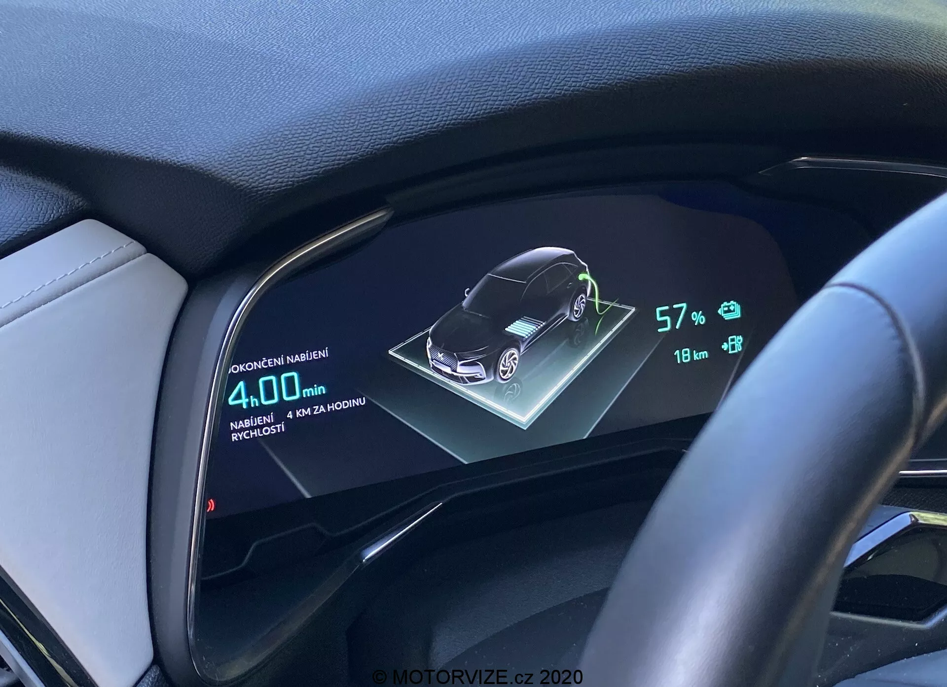 Affichage numérique du tableau de bord d'une DS Automobiles DS-7 2018 (DS-7 Crossback) montrant une représentation graphique 3D du véhicule, batterie à 57%, autonomie de 18 km et consommation moyenne de carburant de 4,0L/100km, vue depuis le conducteur avec volant et tableau de bord en cuir.