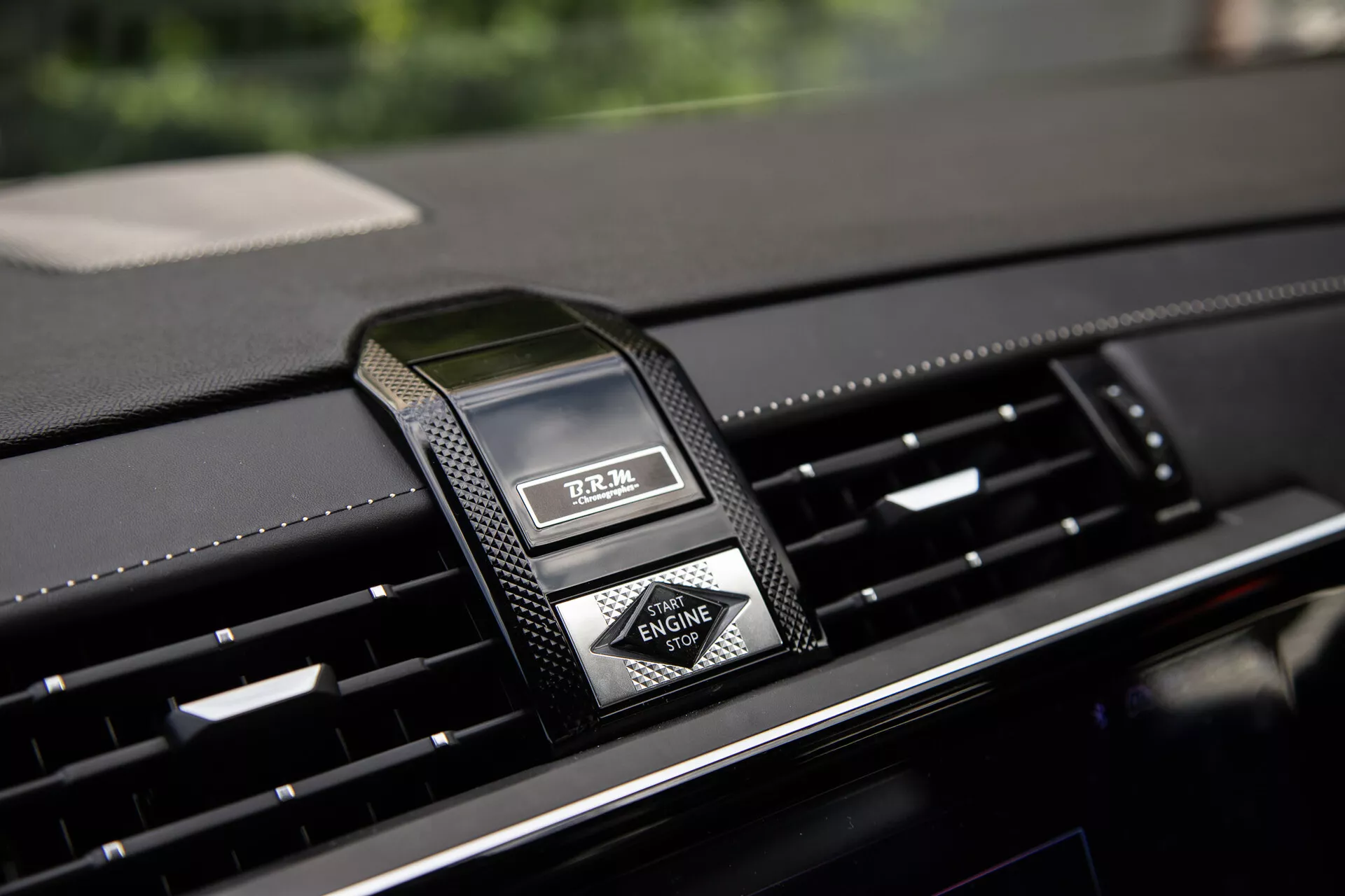 Gros plan sur le tableau de bord central de la DS Automobiles DS-7 2022 avec horloge analogique de luxe et aérations, mettant en avant des matériaux haut de gamme et un design moderne