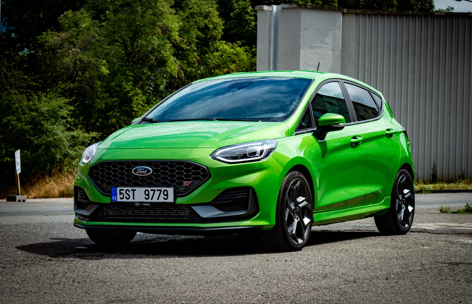 Hatchback Ford Fiesta 2022 vert vibrant en vue avant trois quarts montrant la grille avant avec emblème, pare-chocs sportif avec feux de brouillard, phares angulaires aiguisés, contours aérodynamiques, grandes roues en alliage noir et système d'éclairage moderne