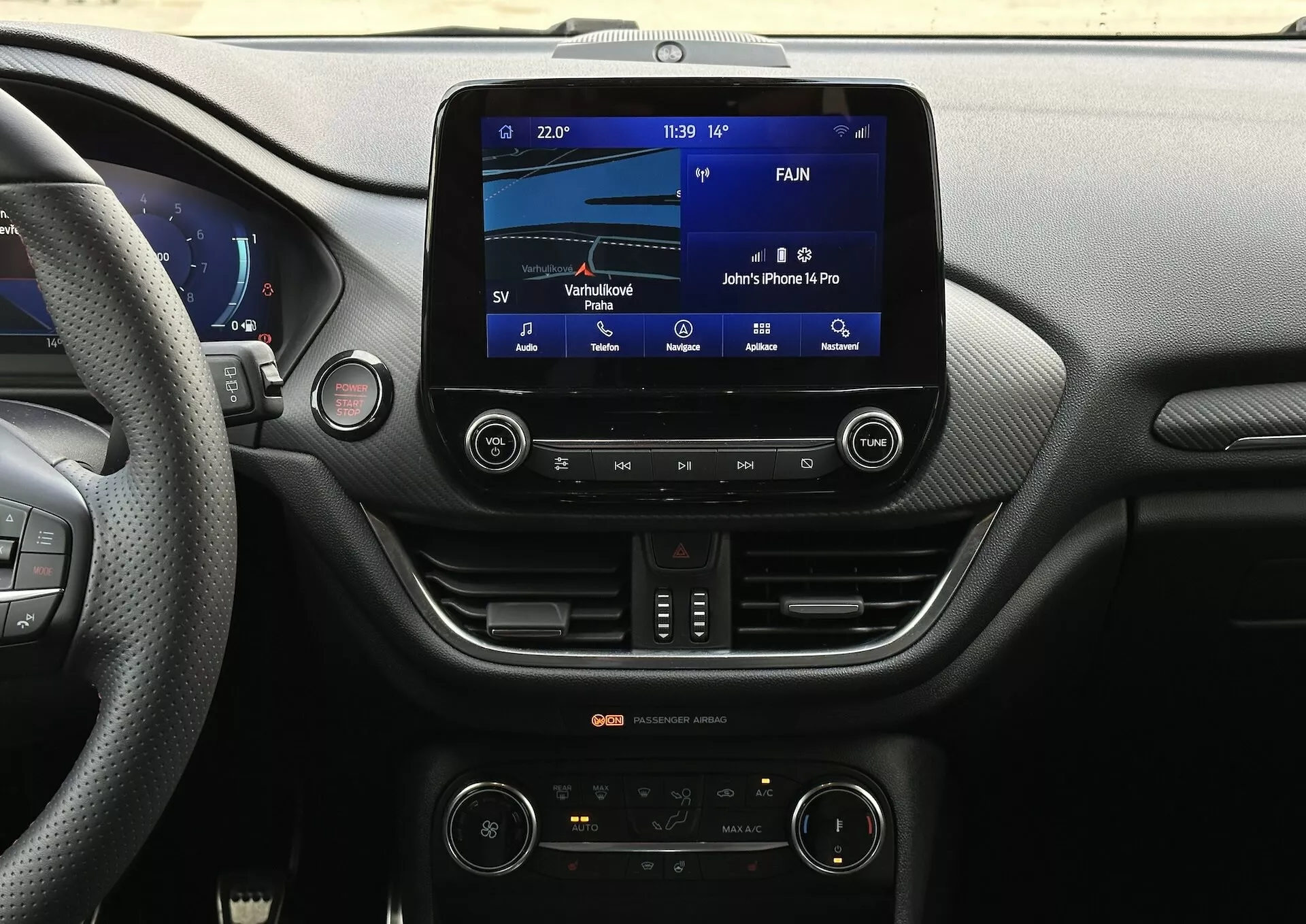 Vue du tableau de bord intérieur de la Ford Fiesta 2022 depuis le siège du conducteur, se concentrant sur le système d'infodivertissement et les caractéristiques de la console centrale, y compris l'affichage tactile, la connectivité Bluetooth et le contrôle climatique bi-zone