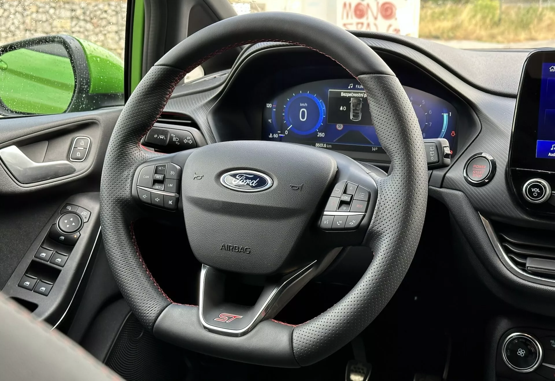 Vue intérieure de la Ford Fiesta 2022 centrée sur le volant à trois branches en cuir avec commandes multifonctions et tableau de bord numérique du point de vue du siège conducteur