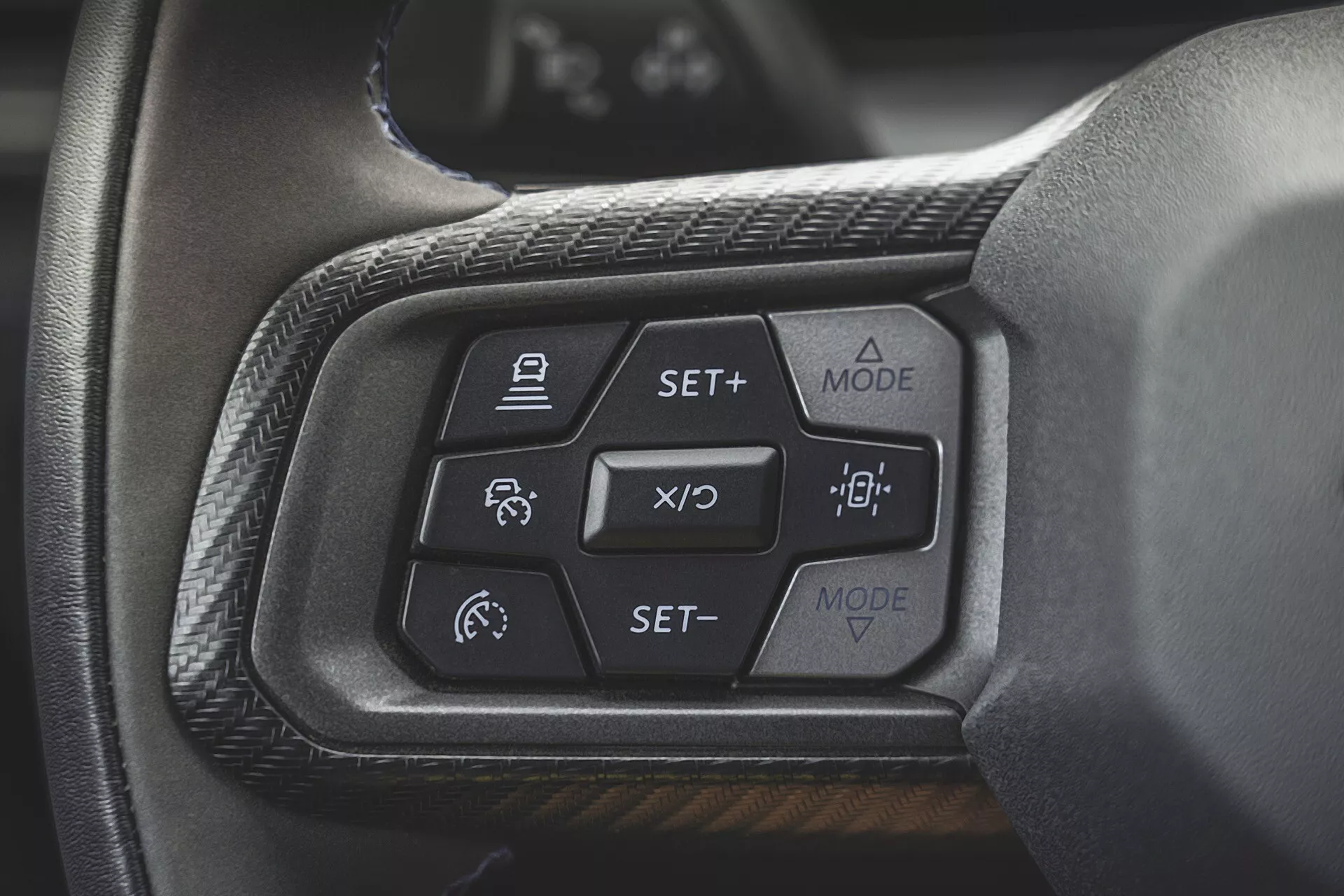 Gros plan sur les commandes du volant de la Ford Mustang 2024 de deuxième génération mettant en évidence le régulateur de vitesse adaptatif, l'assistance au maintien de voie et les boutons de mode d'affichage du tableau de bord, vus du point de vue du siège conducteur