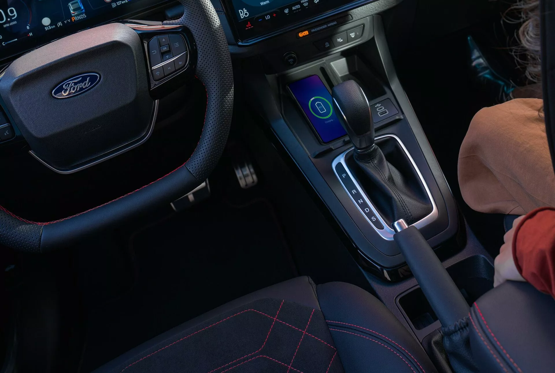 Vue intérieure de la Ford Puma II facelift 2024 axée sur la console centrale et le volant avec tableau de bord numérique et système d'infodivertissement tactile